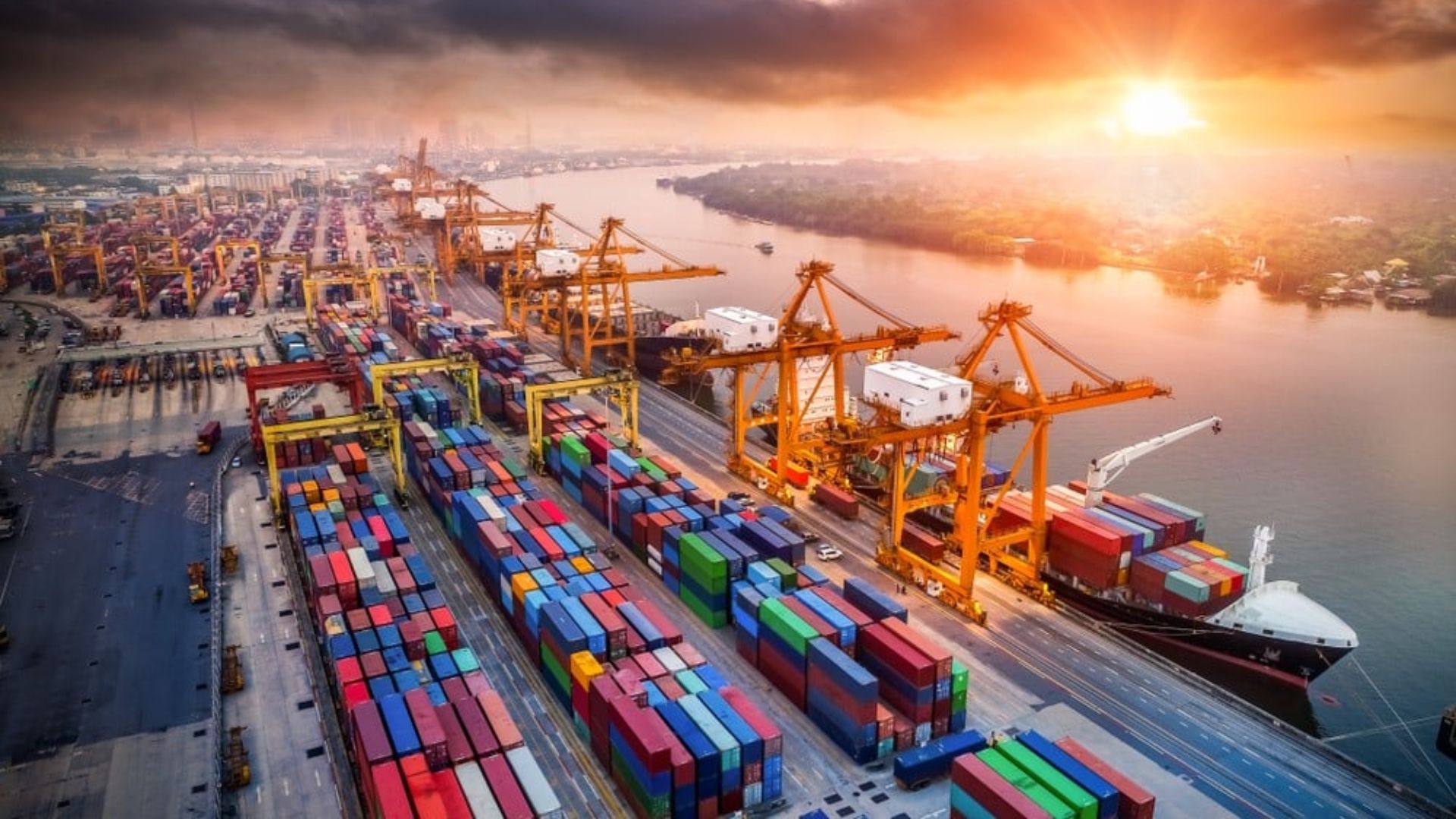 Aerial view of a busy port filled with colorful shipping containers and cargo vessels docked along the waterfront.