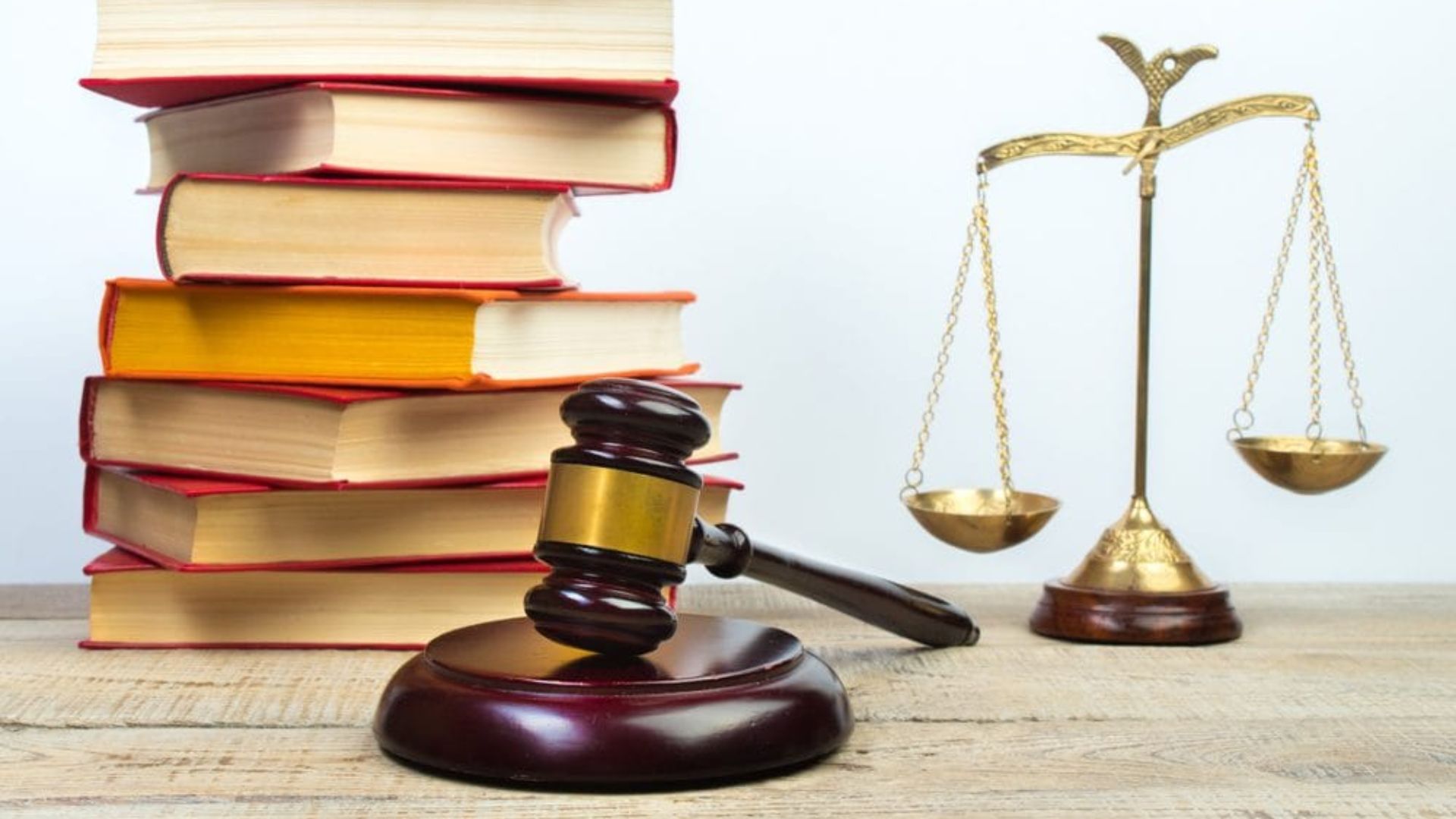 Gavel resting on law books atop a wooden table, symbolizing the concepts of law and justice.