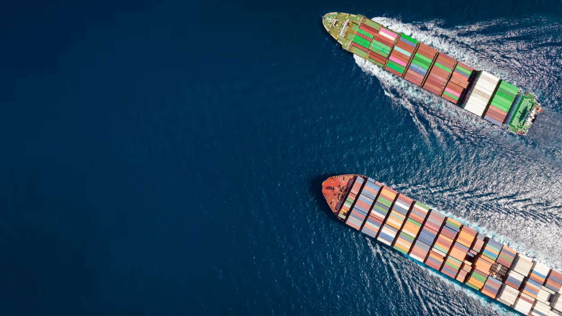 Two cargo vessels positioned in the ocean, with gentle waves and a bright horizon.