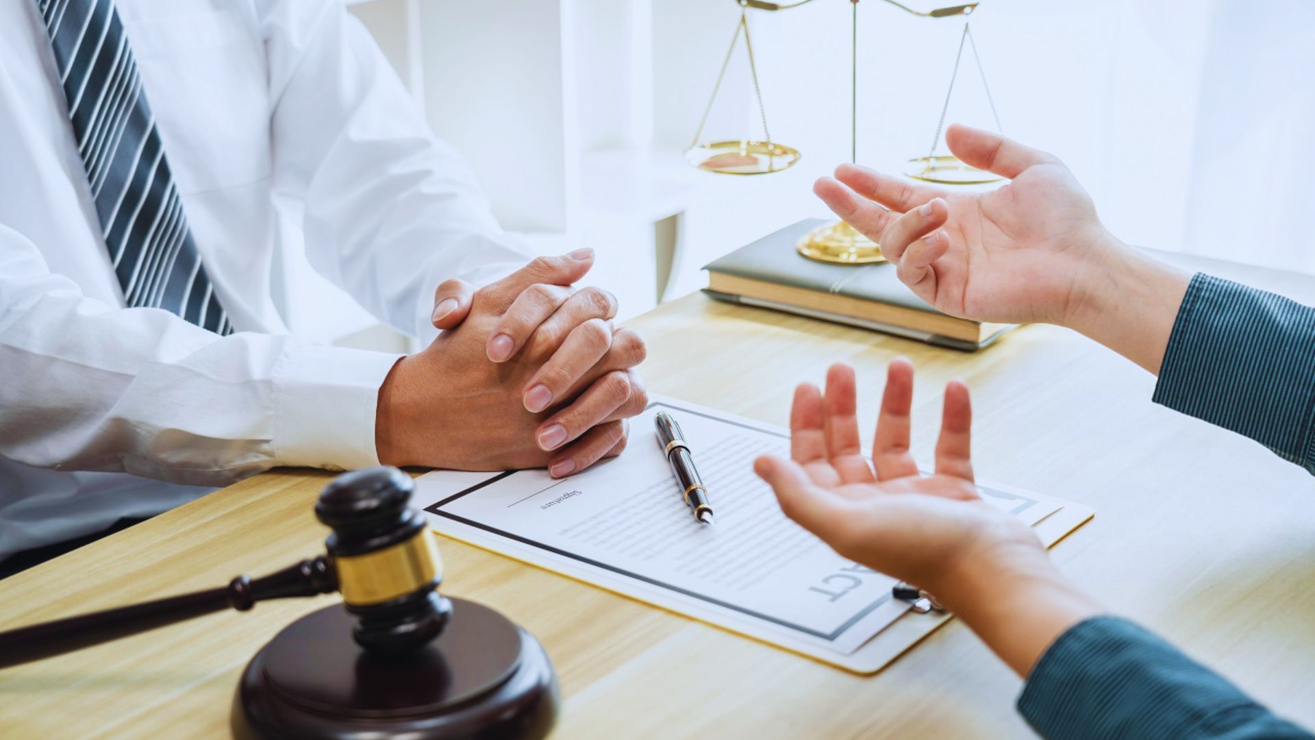 A lawyer and a client discussing a case in a courtroom, surrounded by legal documents and a judge's bench in the background.