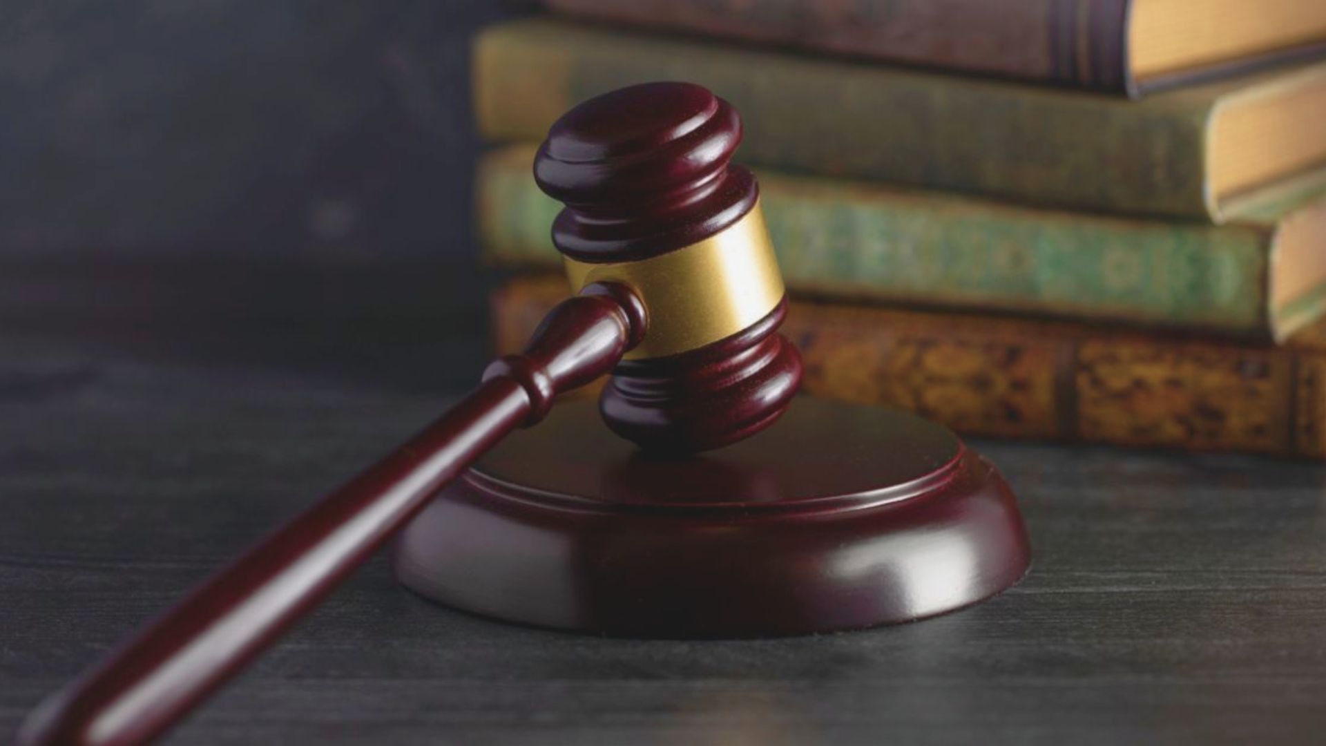 A judge's gavel resting on a stack of law books, symbolizing justice and legal authority.