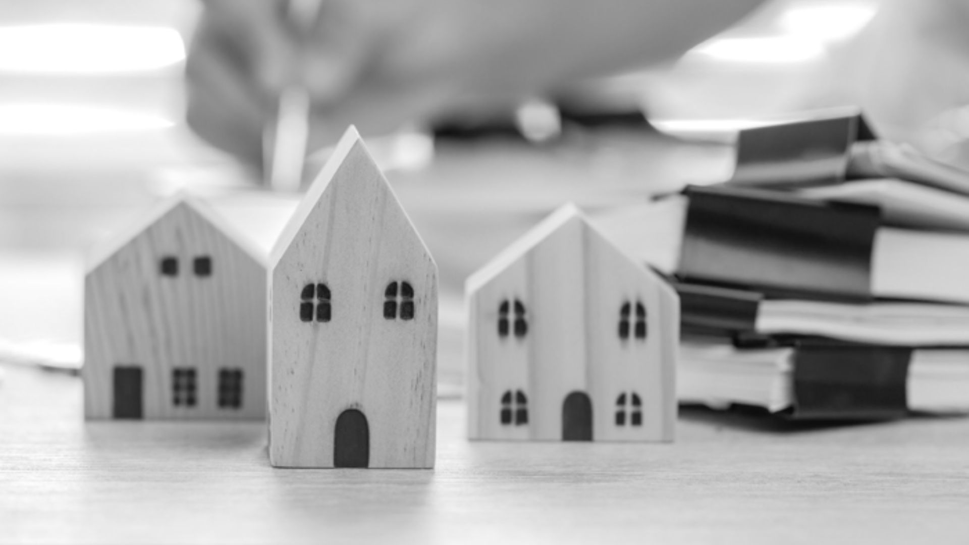 Black and white photo of a detailed house model displayed on a table, showcasing architectural features and design.