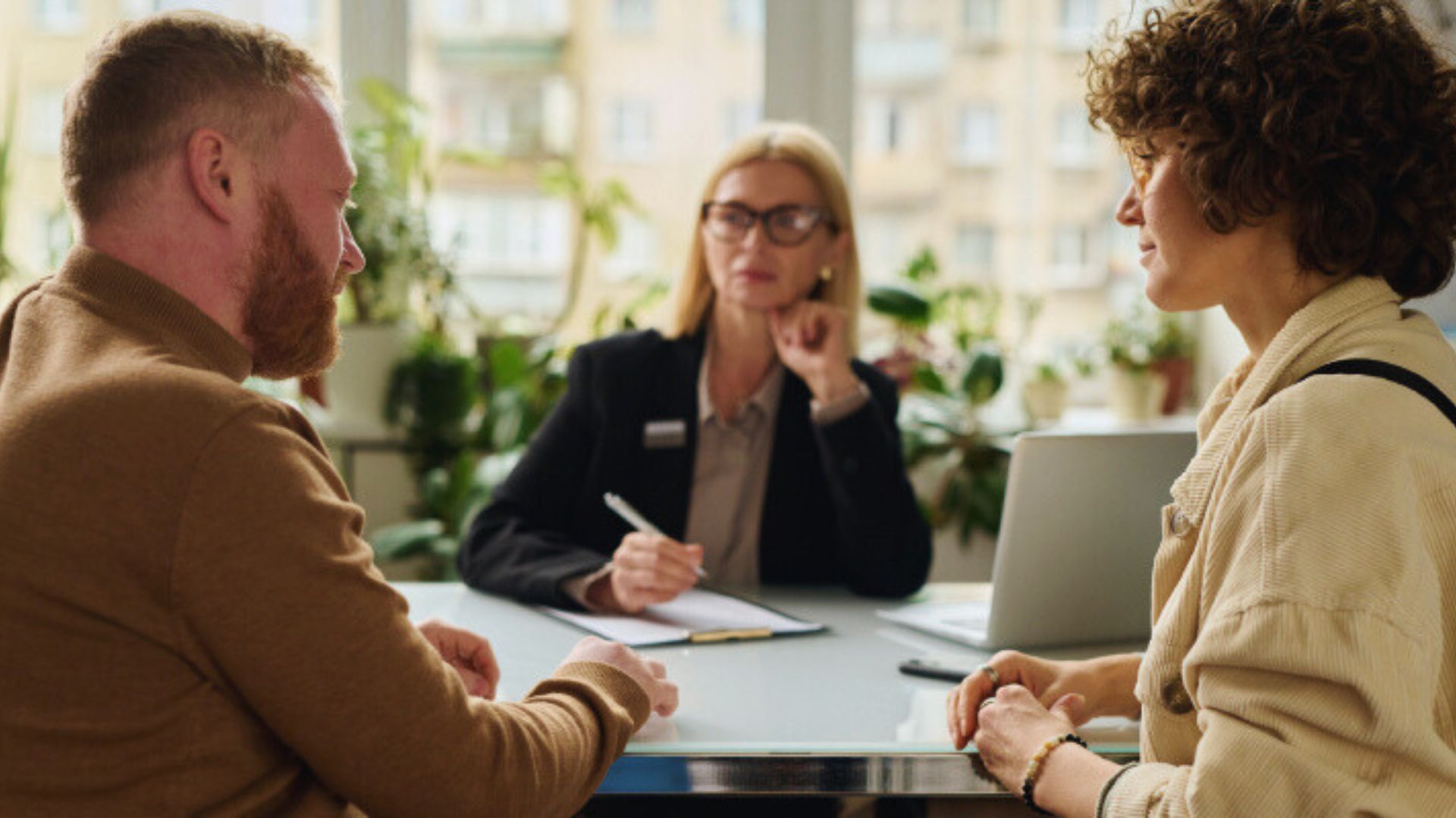 A man and woman engage in conversation with another man and woman in a professional office setting.