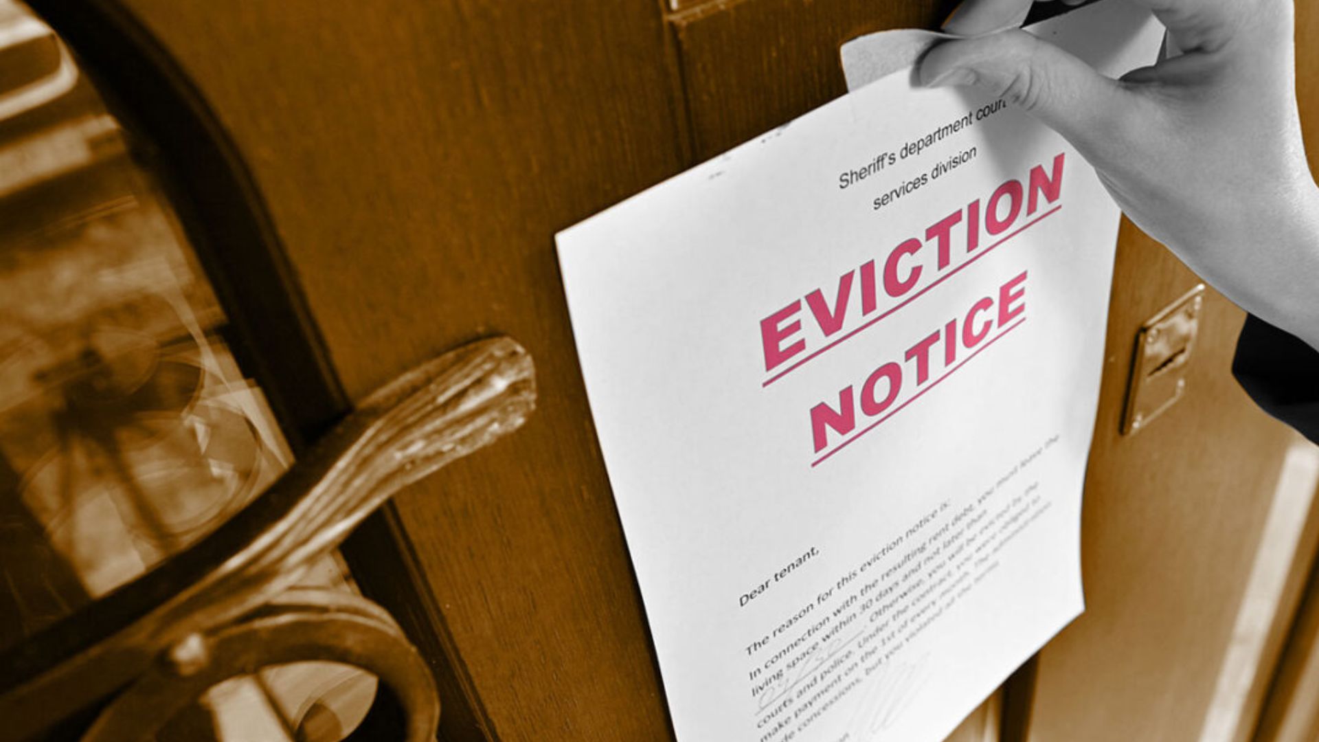 A person holding an eviction notice, conveying a sense of urgency and distress regarding housing security.