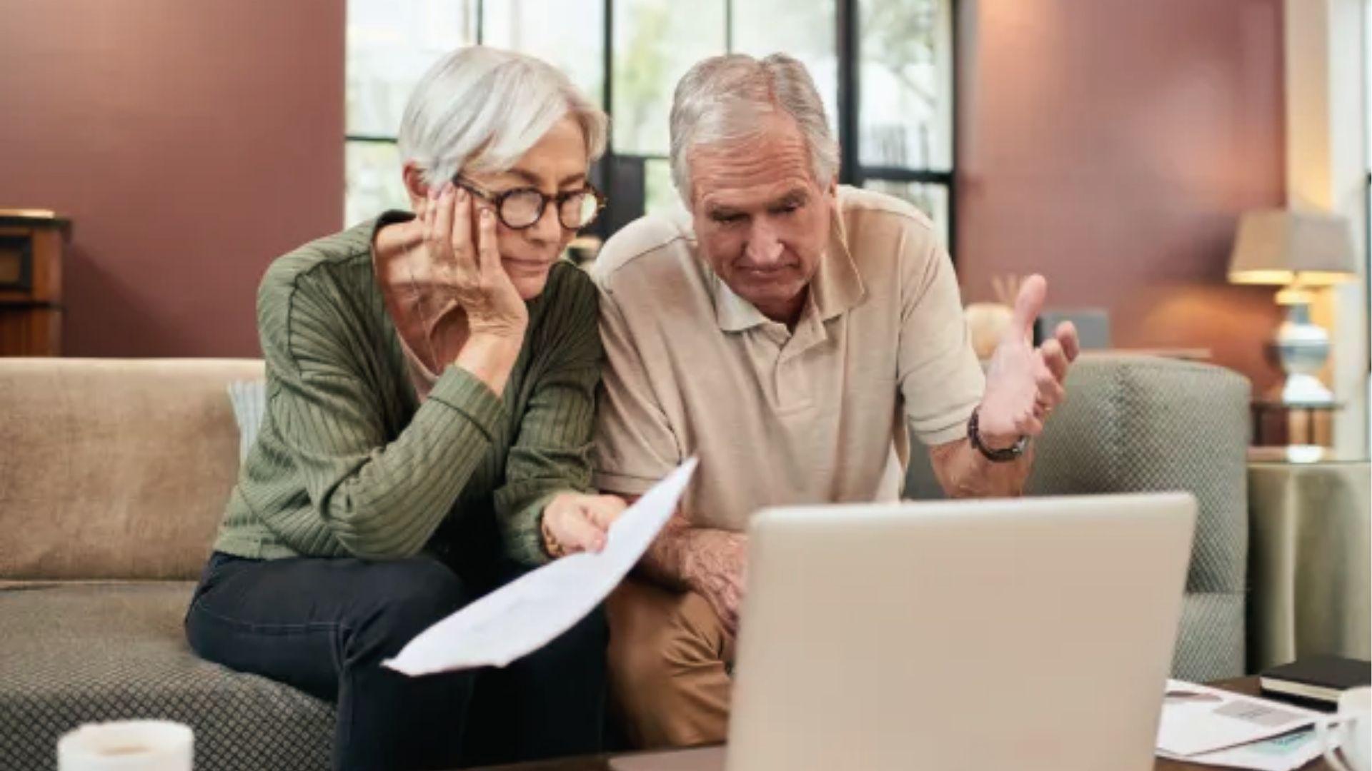Senior couple discusses will on laptop at home to understand Per Capita estate planning options.