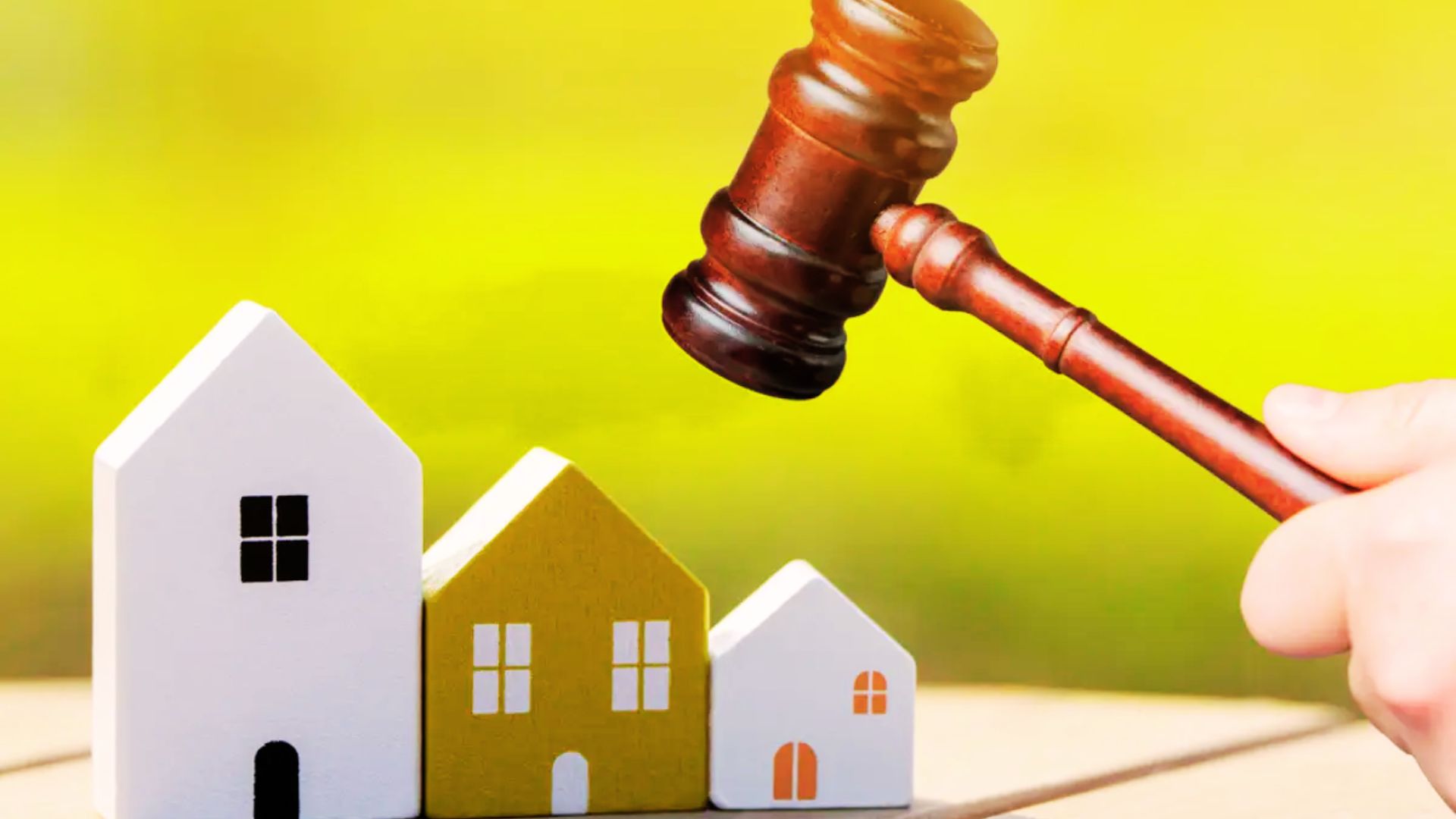A gavel hits a house model, representing judicial actions that assist in avoiding probate complications.