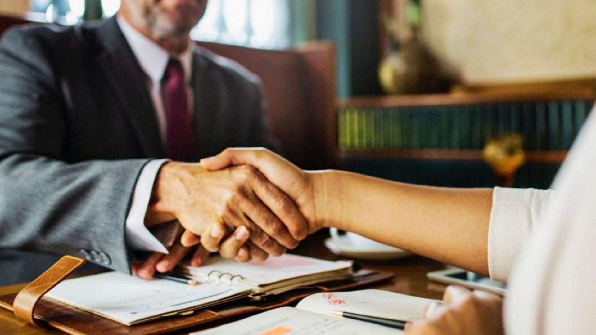 Business handshake between heirs and real estate lawyer finalizing agreement to sell inherited property after mutual consent