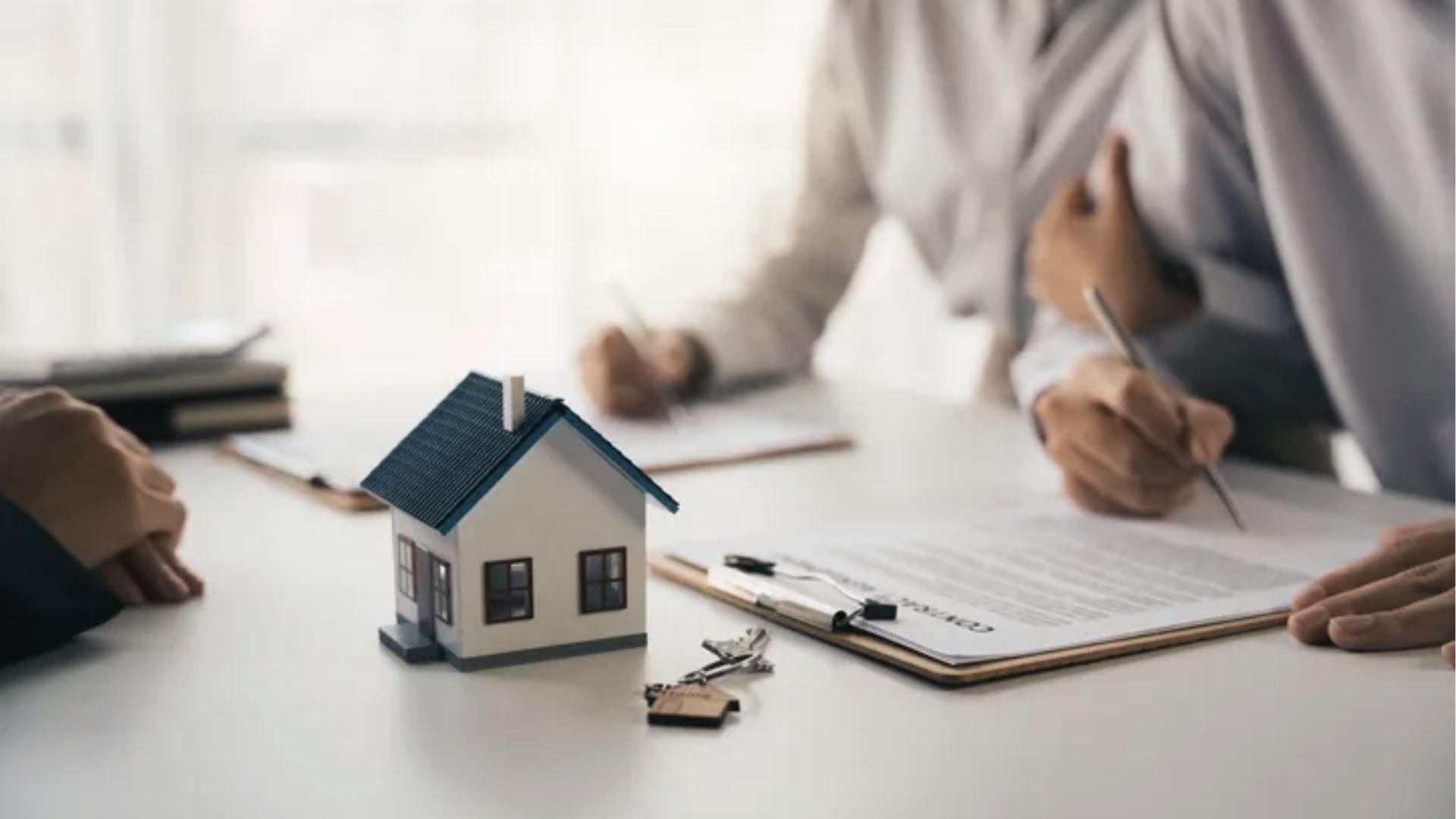 Model house with keys and contract on desk represents closing estate account versus trust account