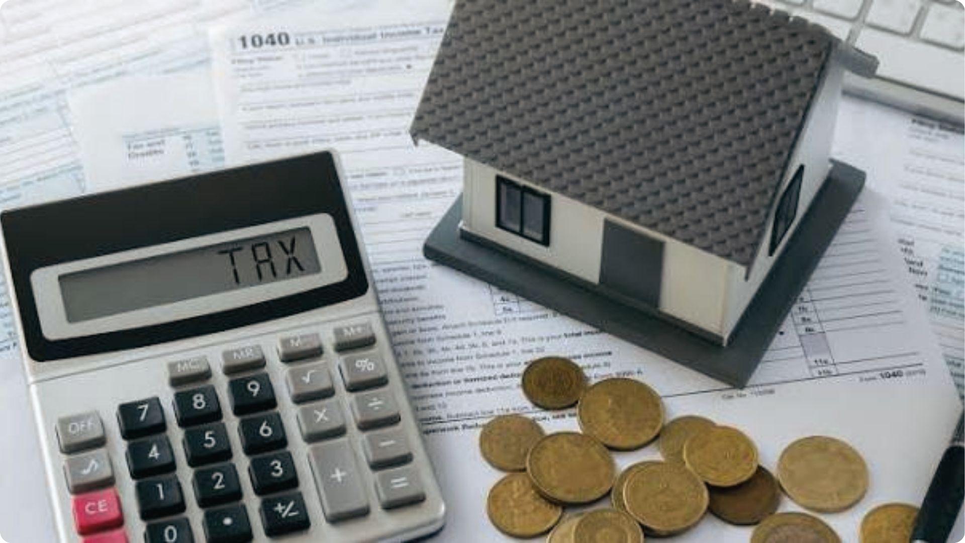Calculator showing TAX with model house and coins on forms revealing wrong property tax valuation