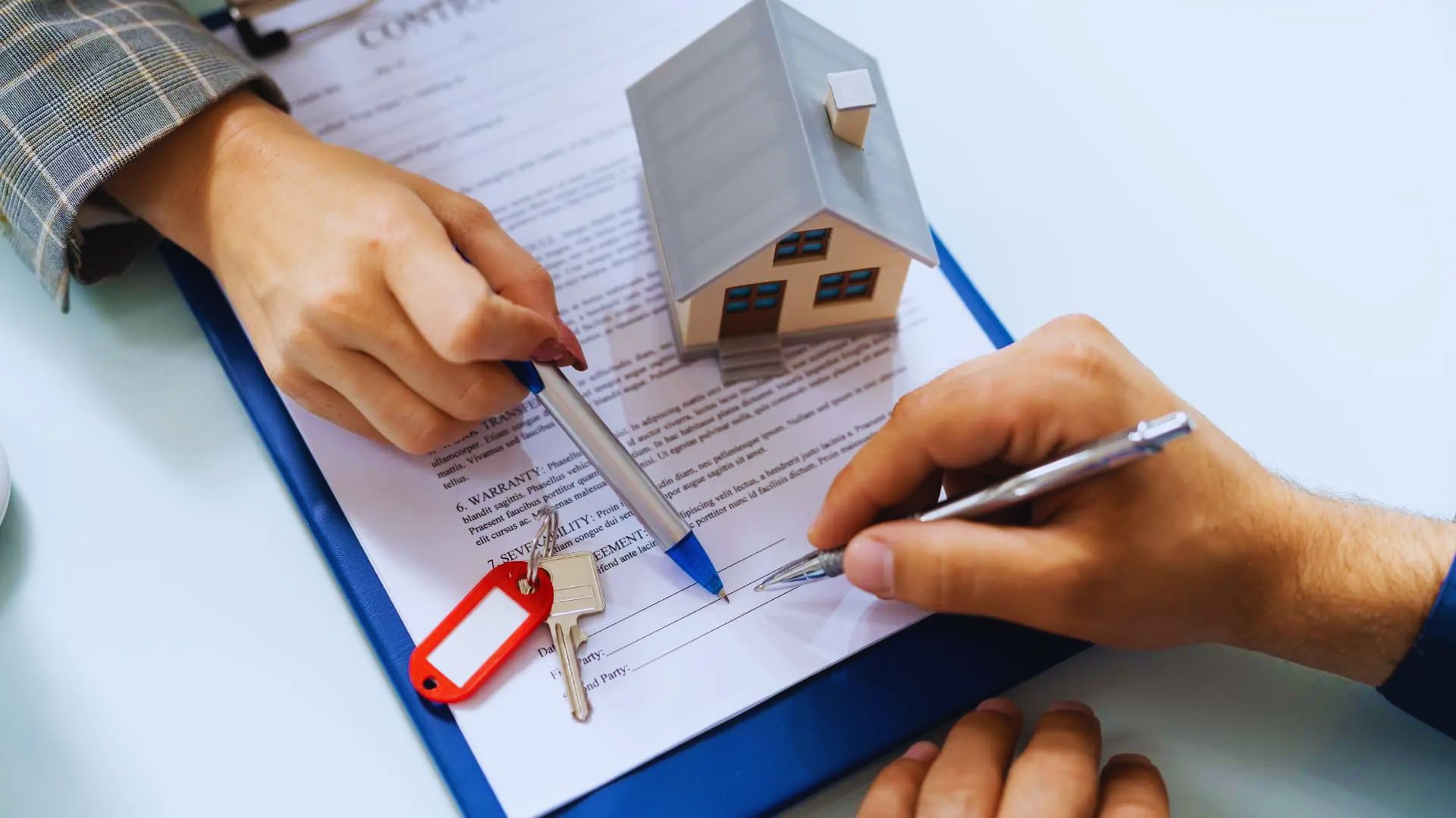 A close-up of a house deed with a pen and legal documents, the process of name removal in property ownership.