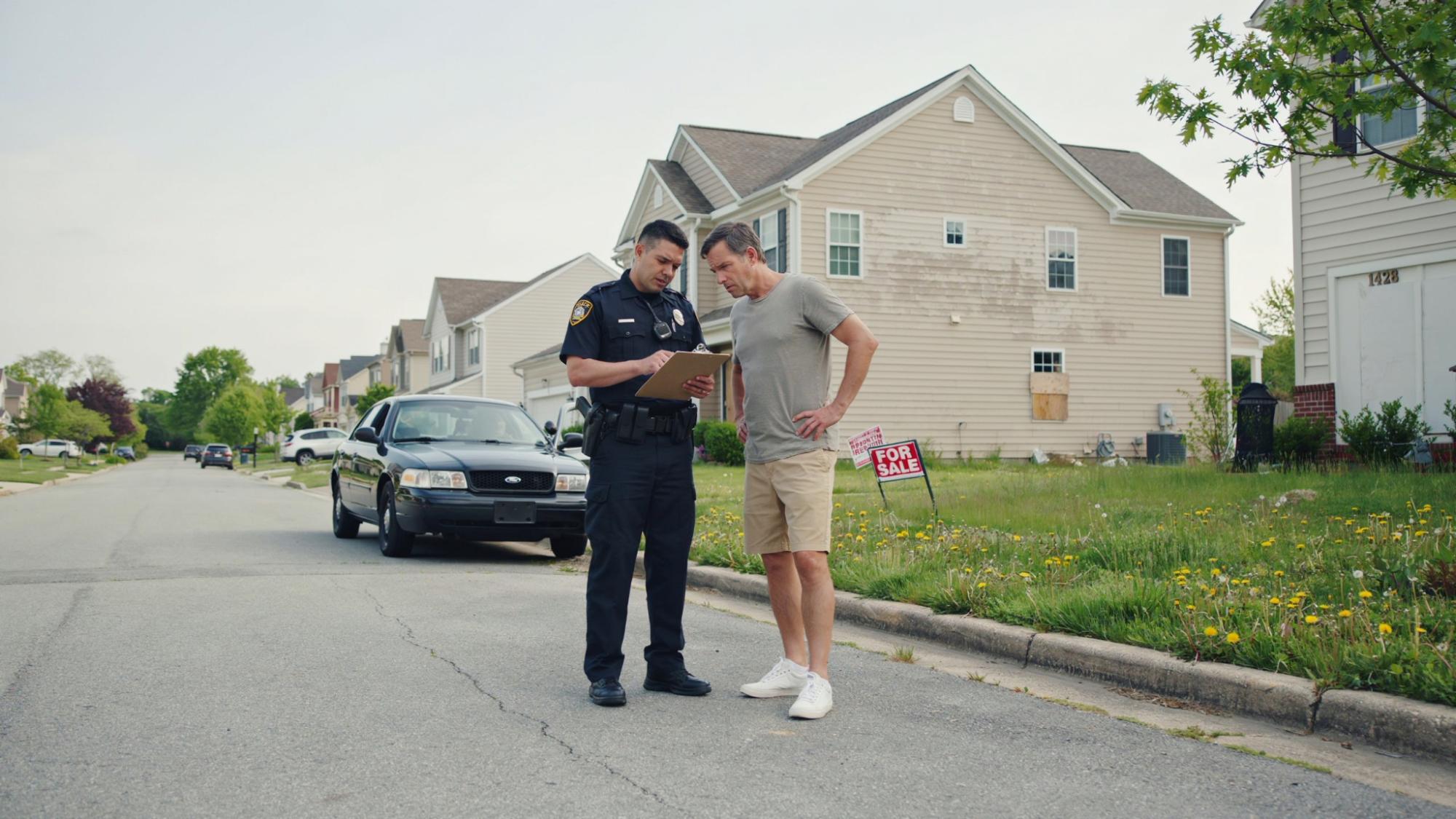 police officer discussing a squatter complaint with a property owner