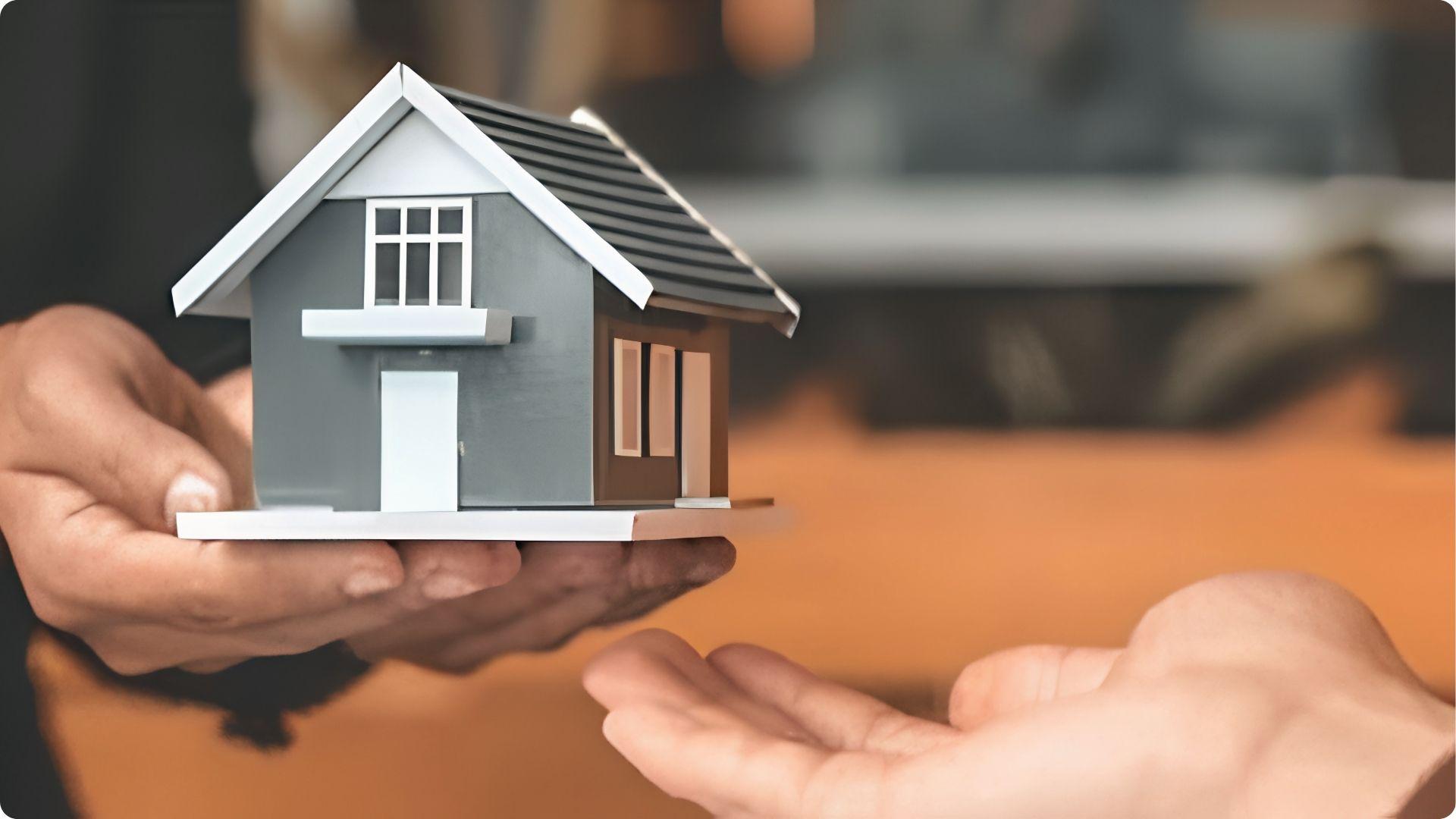 Hands exchanging model house showing your right to sell or transfer mobile home ownership legally.