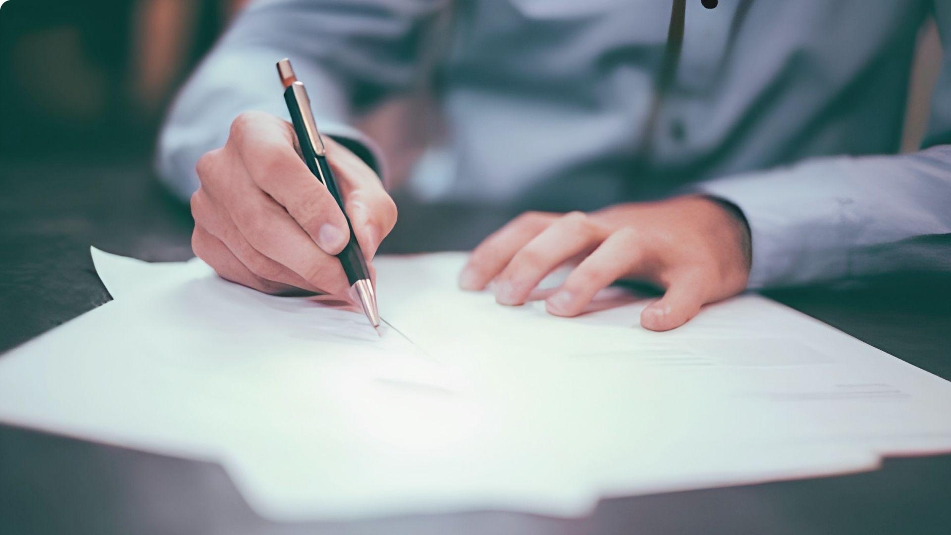 Person signing legal warranty deed to complete ownership transfer