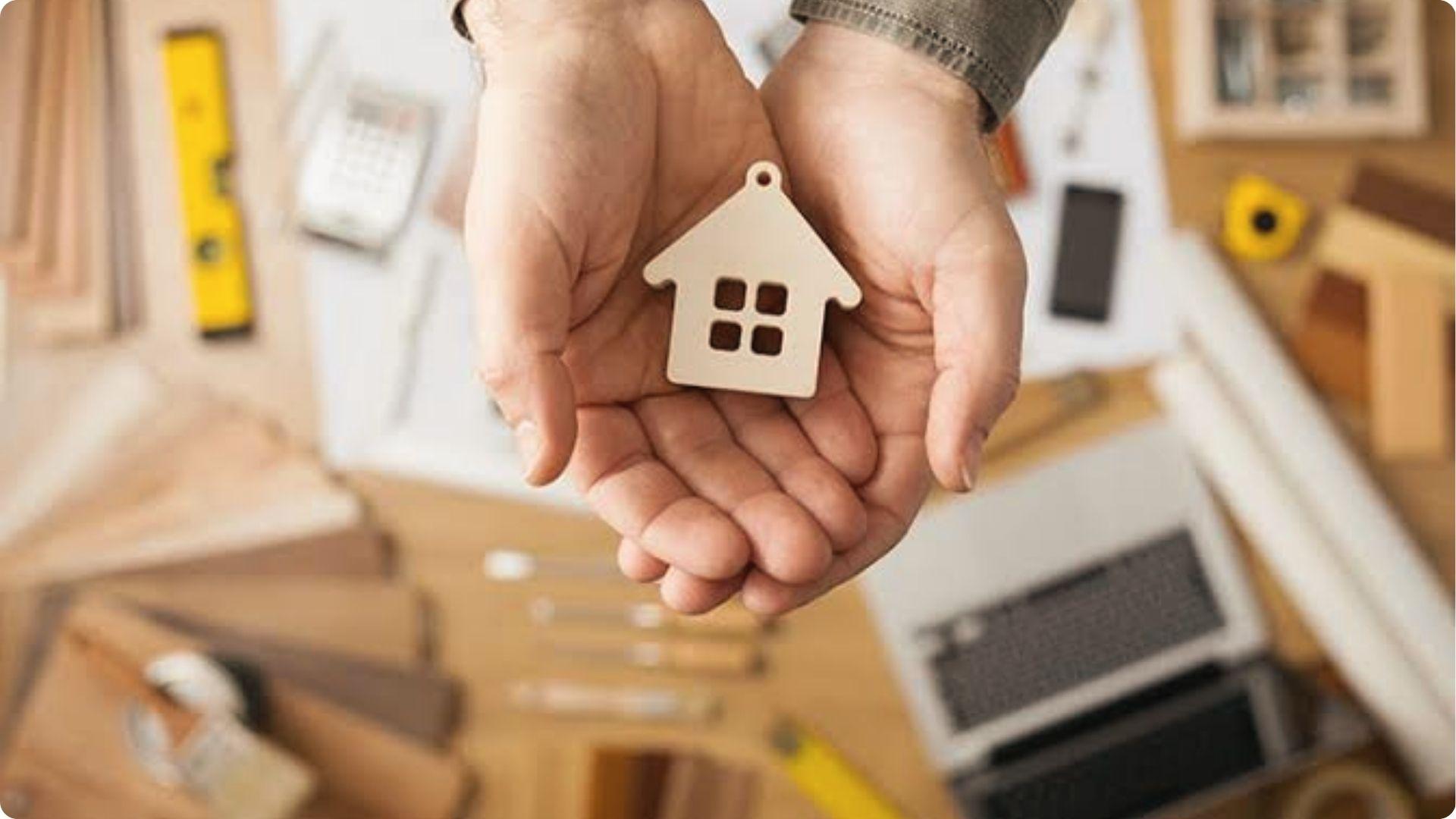 Hands holding wooden house model symbolizing tenants in common conflict over property division