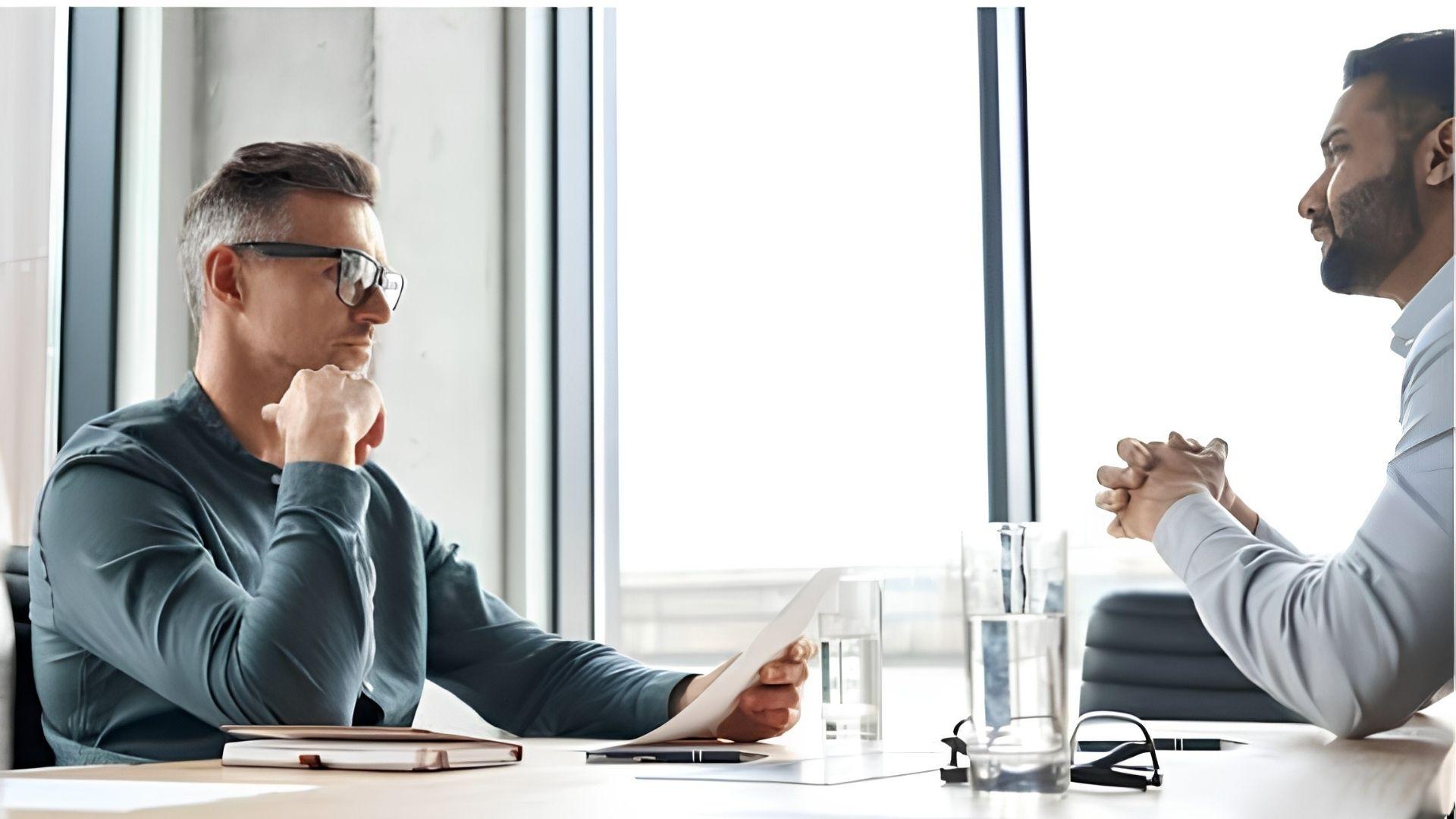 Real estate consultation between client and property lawyer reviewing documents.