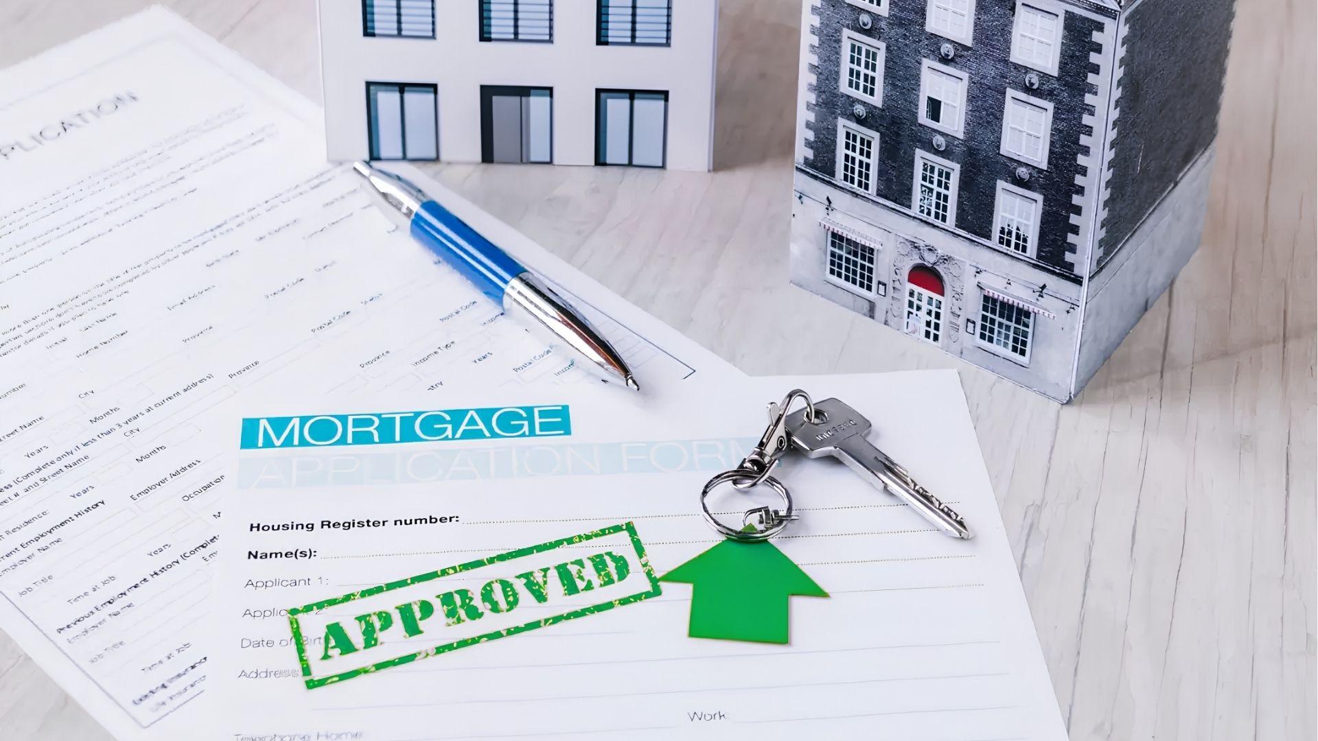 Approved mortgage application form with pen, house keys, and building models