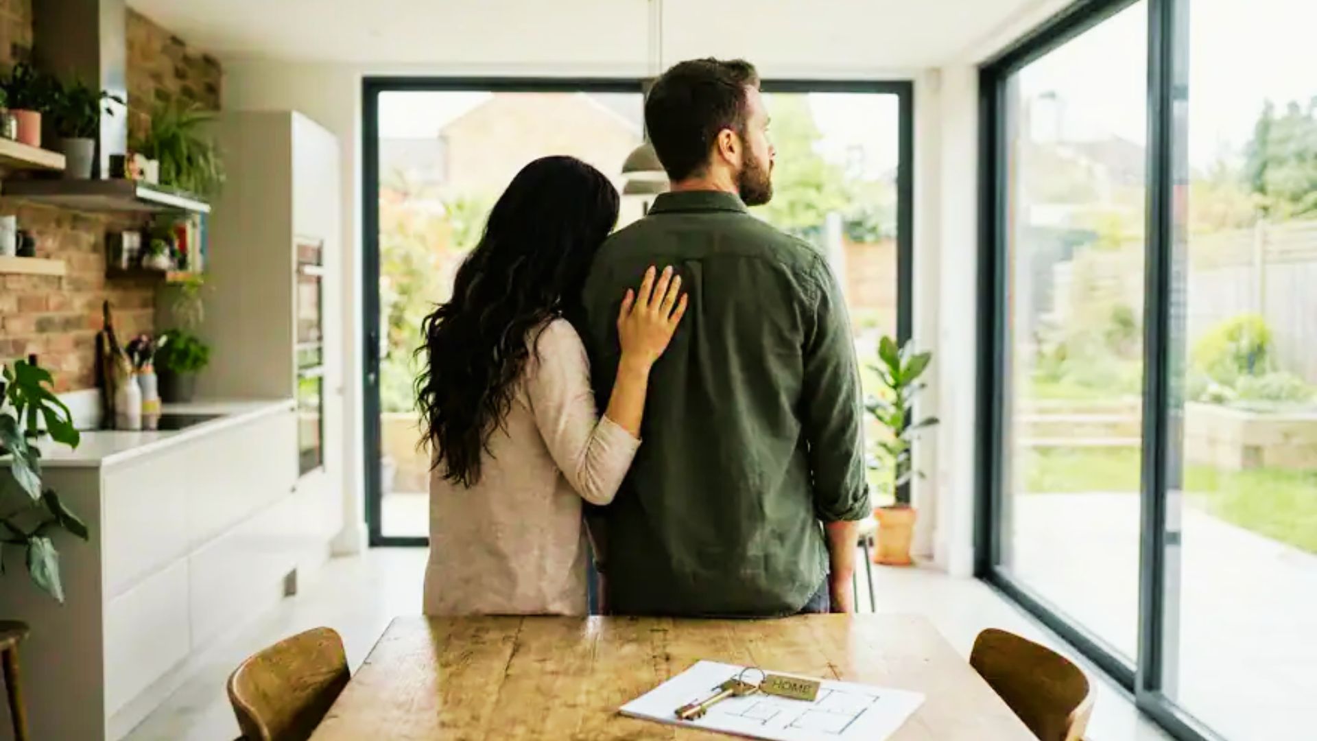 Unmarried couple in a kitchen, contemplating property ownership and legal considerations for their shared assets.