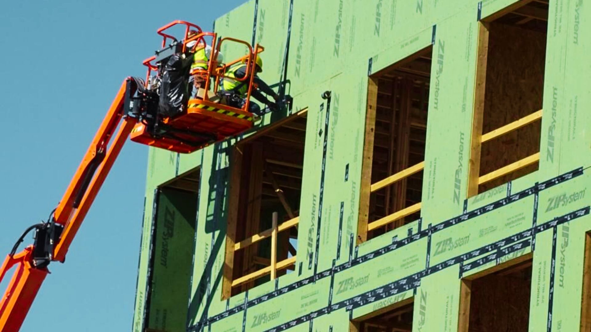 A team of construction workers on a lift, engaged in building work, construction activities in progress.