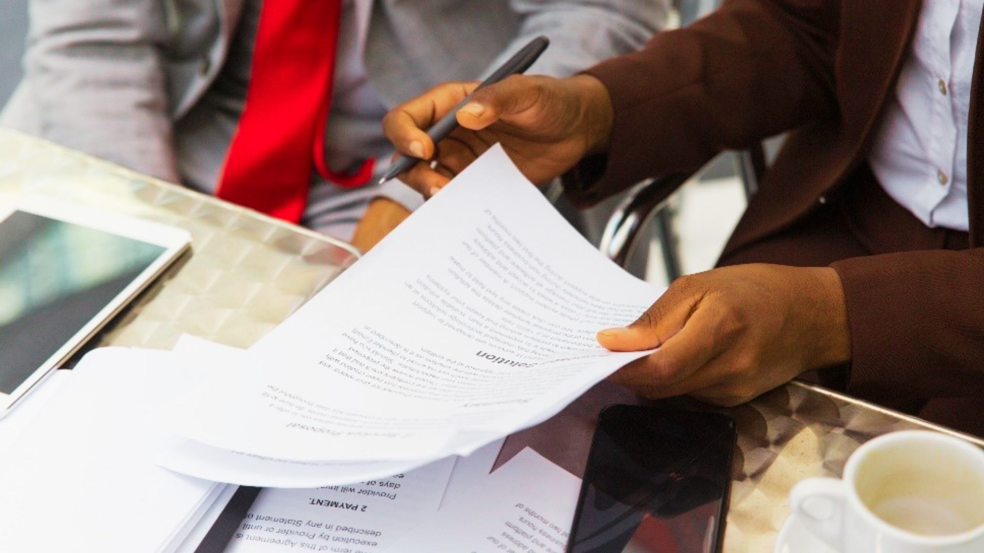 A man in a suit holds a pen and paper, contemplating legal matters regarding deed name removal.