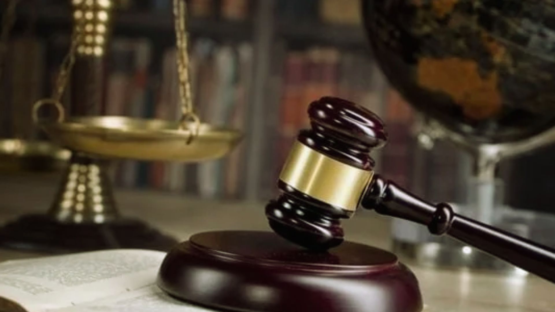 Judge gavel on sounding block with justice scales and law books for quitclaim deed legal proceeding