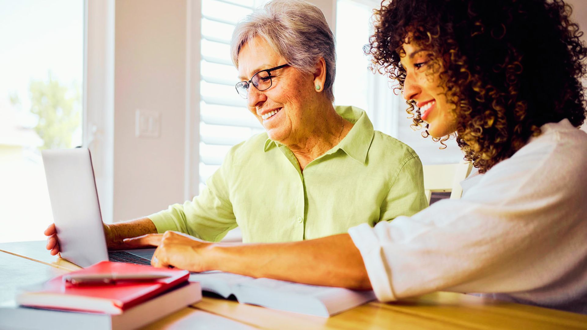 A woman and an older woman collaborate on a laptop, discussing living trust costs and planning for 2026.