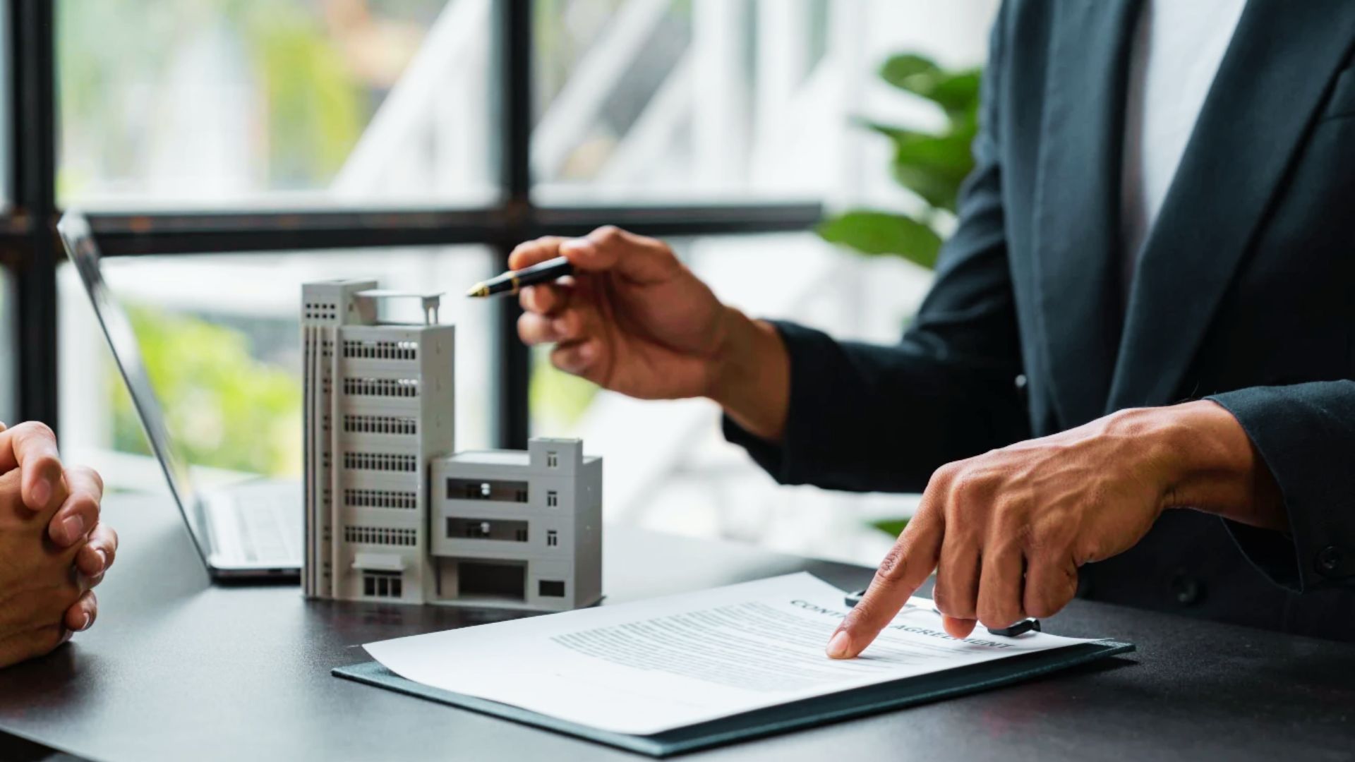 Two business professionals at a table reviewing paperwork and focused on the deed filing process