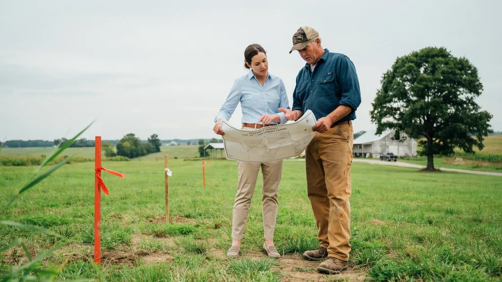 Landowners reviewing survey maps before buying rural property.