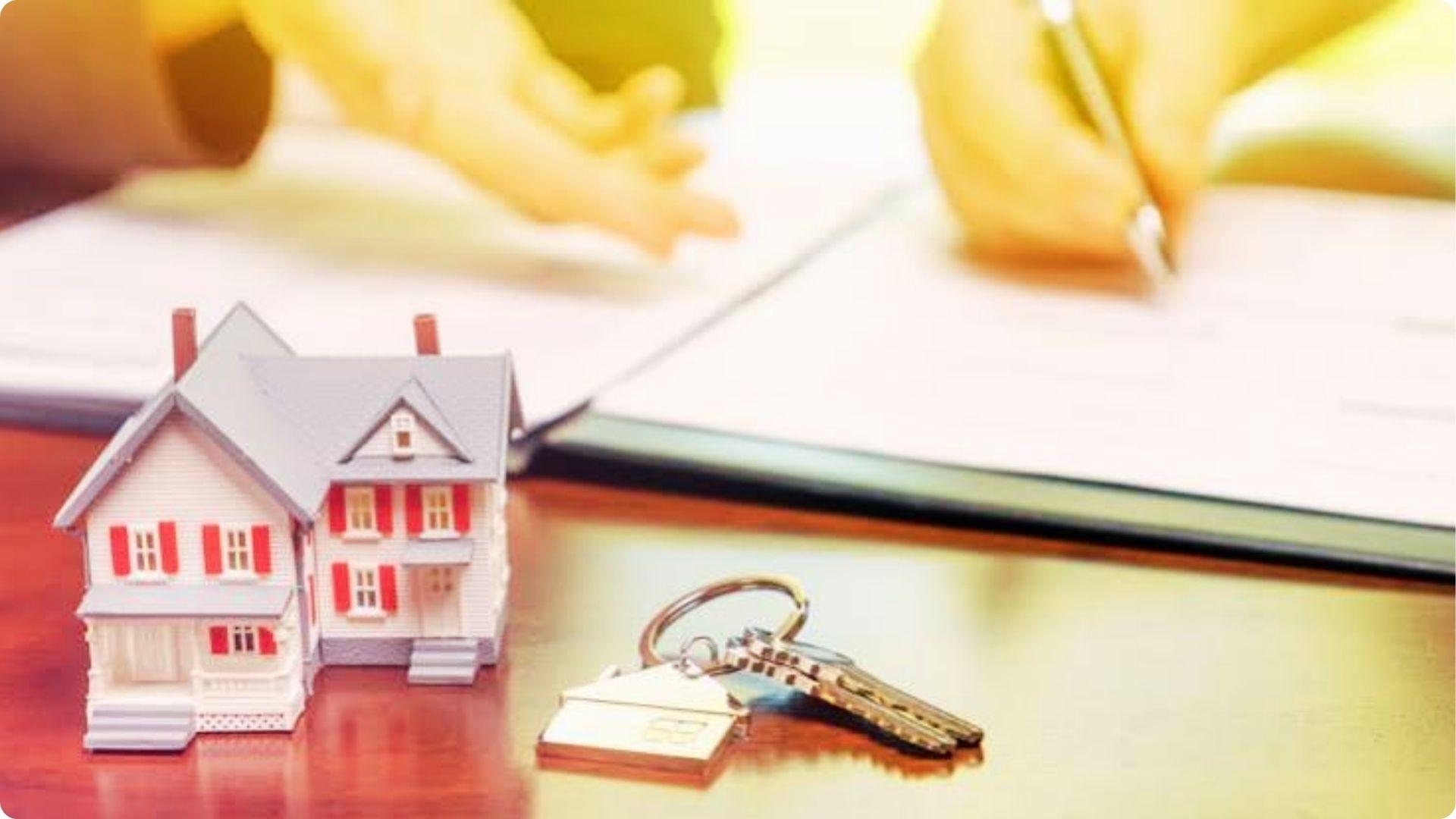 House model with keys on table as lawyer explains deed transfer fees and signing paperwork