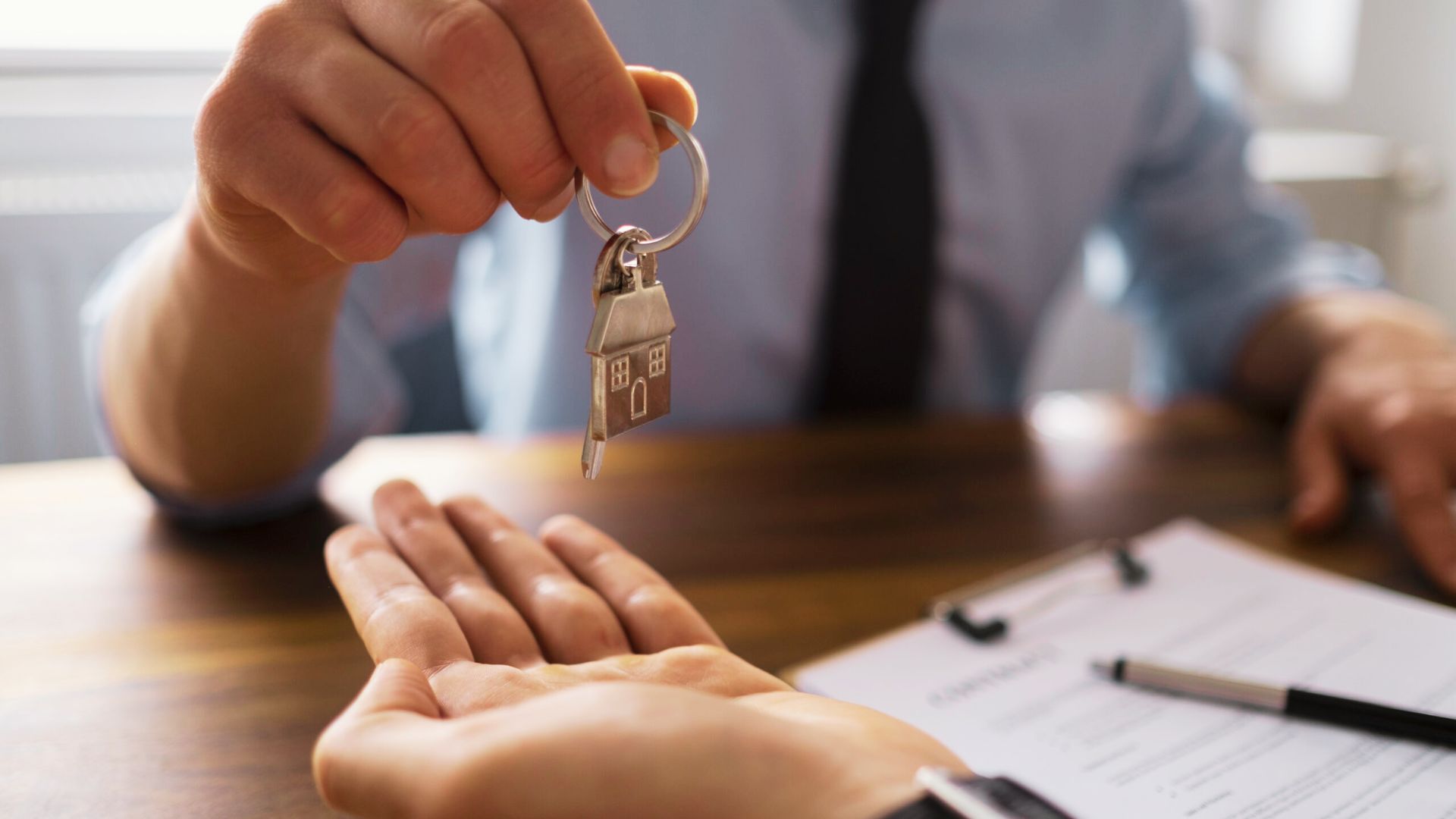 Individual holding a key representing property ownership transfer via a quit claim deed.