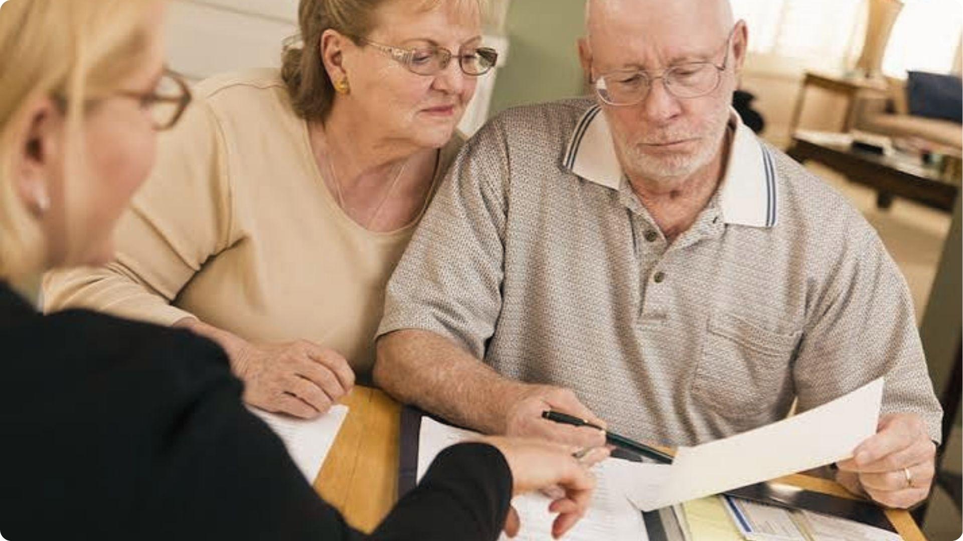 Elderly tenants reviewing injury claim documents with a legal advisor after an accident on property.