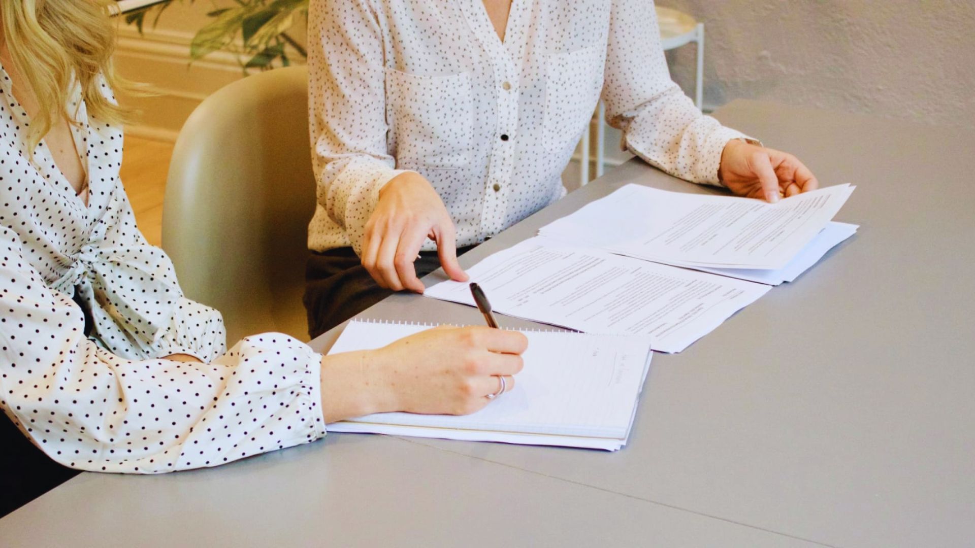 Two women engaged in a conversation about irrevocable trust paperwork.