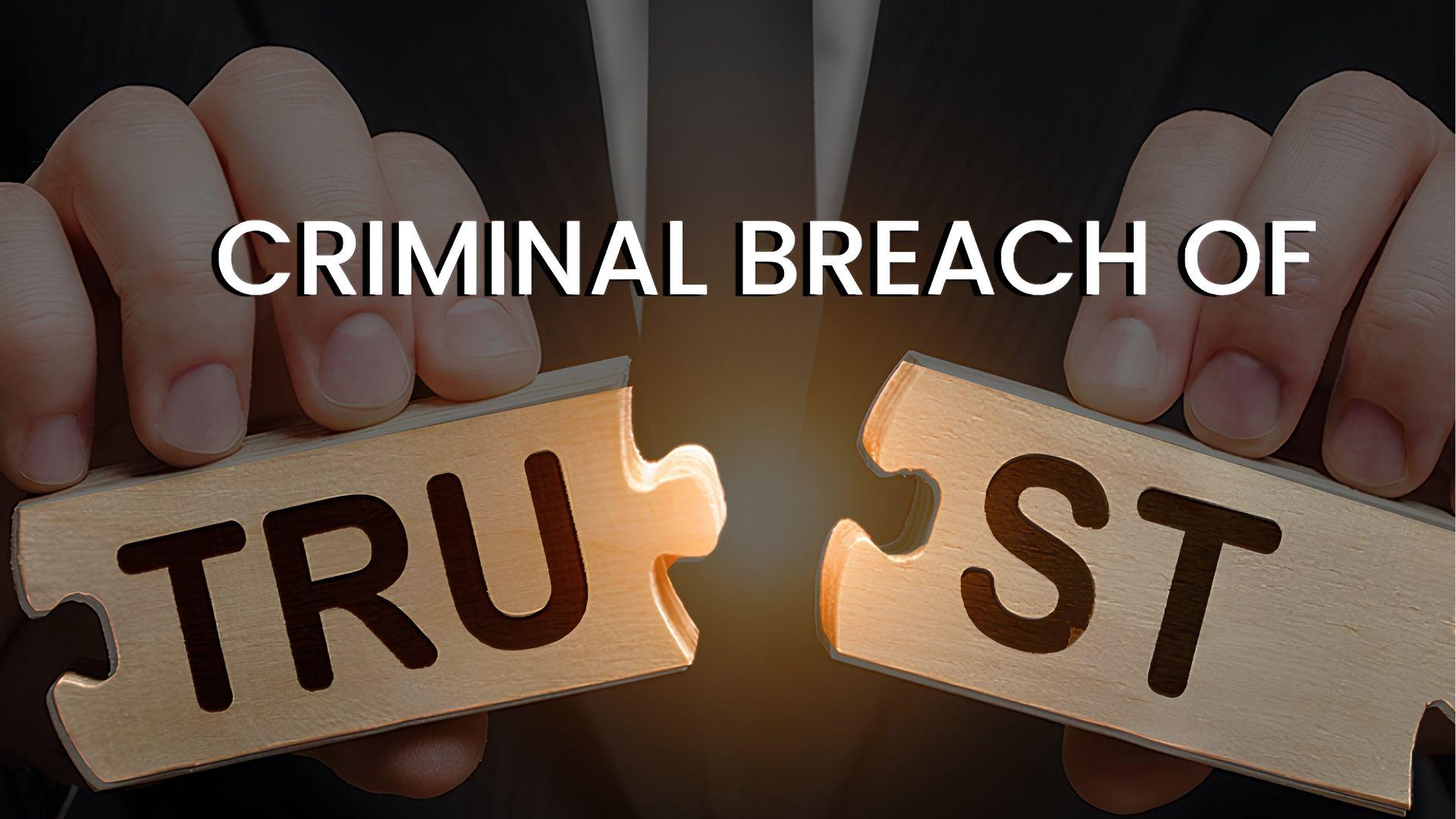 Hands pulling apart a wooden TRUST puzzle, symbolizing criminal breach of trust