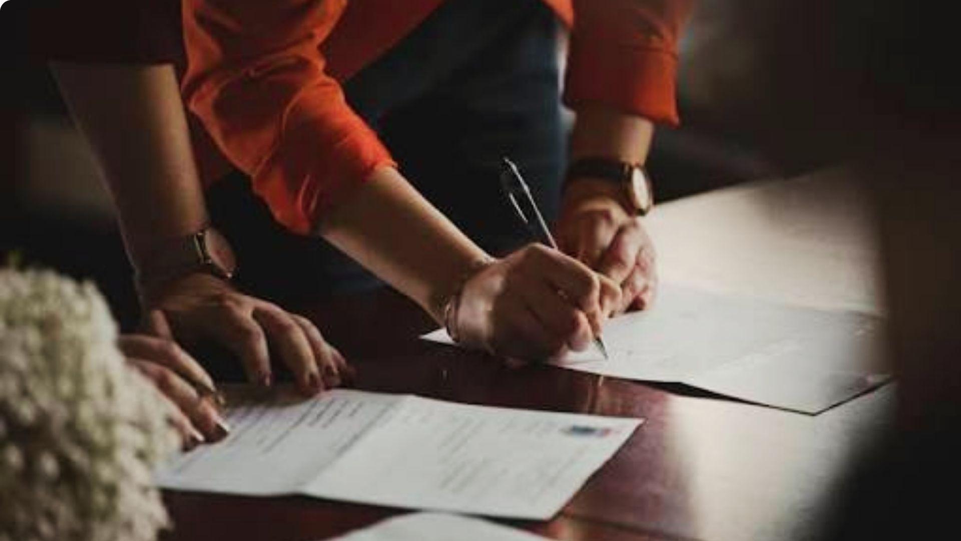 Two people checking warranty deed documents to transfer property ownership