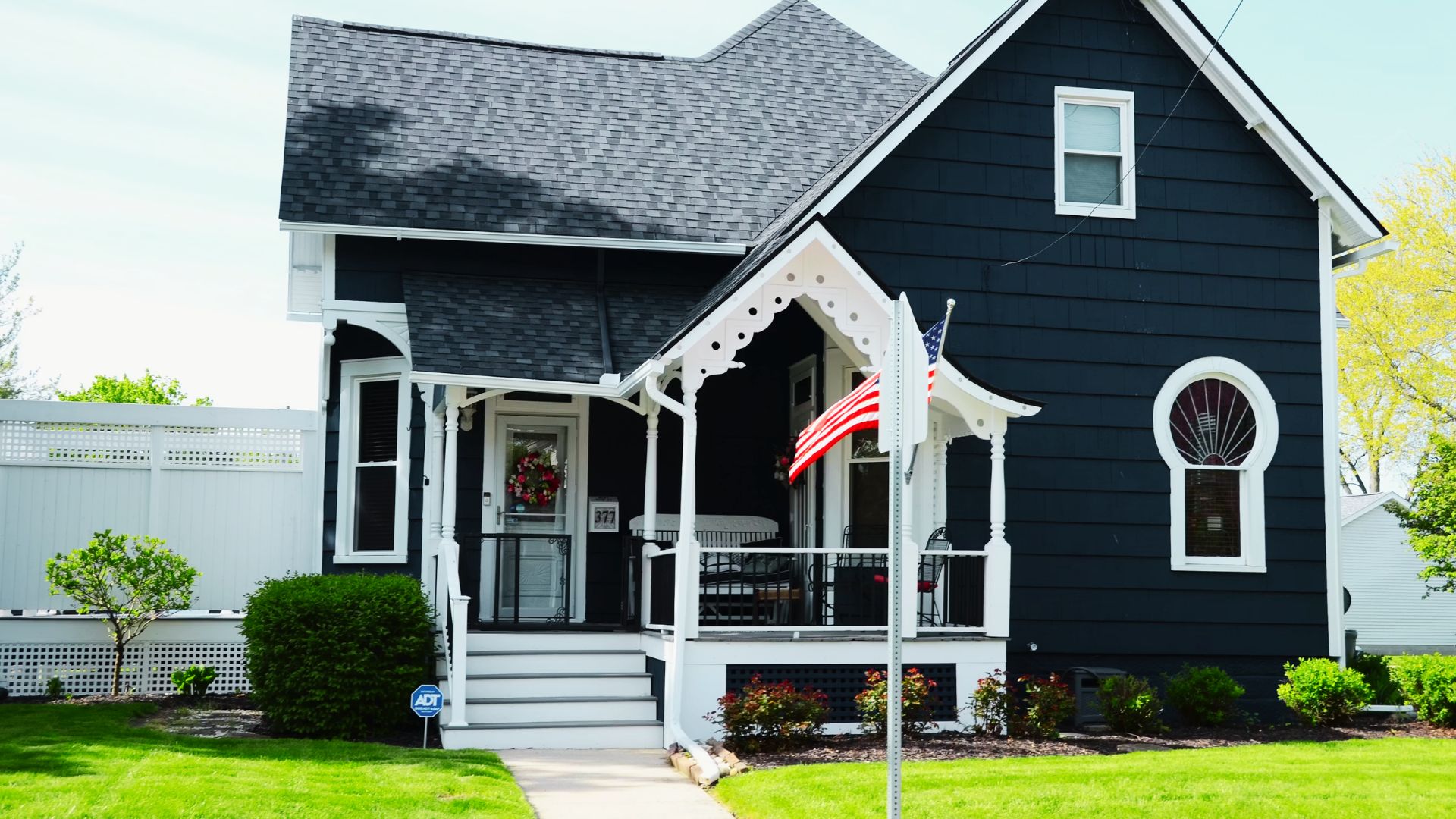 A small blue house with an American flag on the porch, symbolizing community property trust options in real estate.