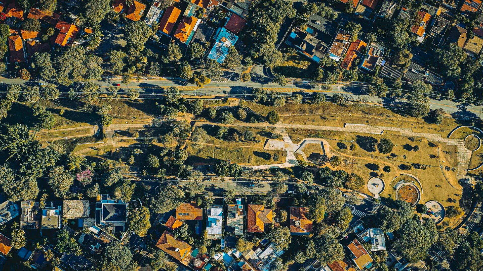 Aerial view of residential neighborhood with central park strip, roads, and homes showing property boundaries and easements