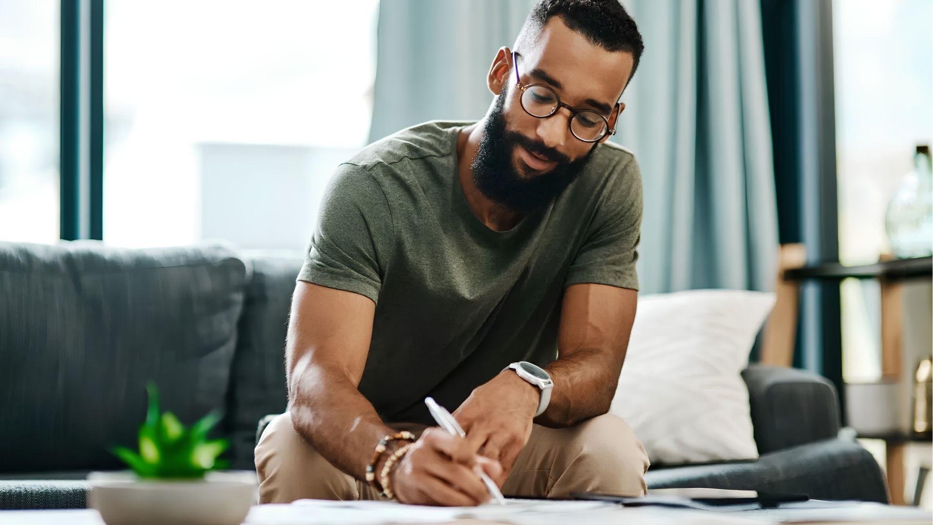 Homebuyer reviewing and signing property documents at home.