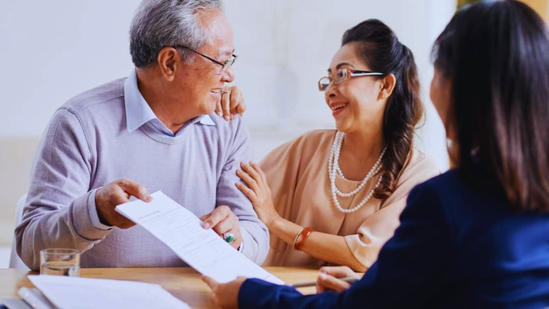 An estate planning lawyer reviewing legal paperwork with a senior couple.