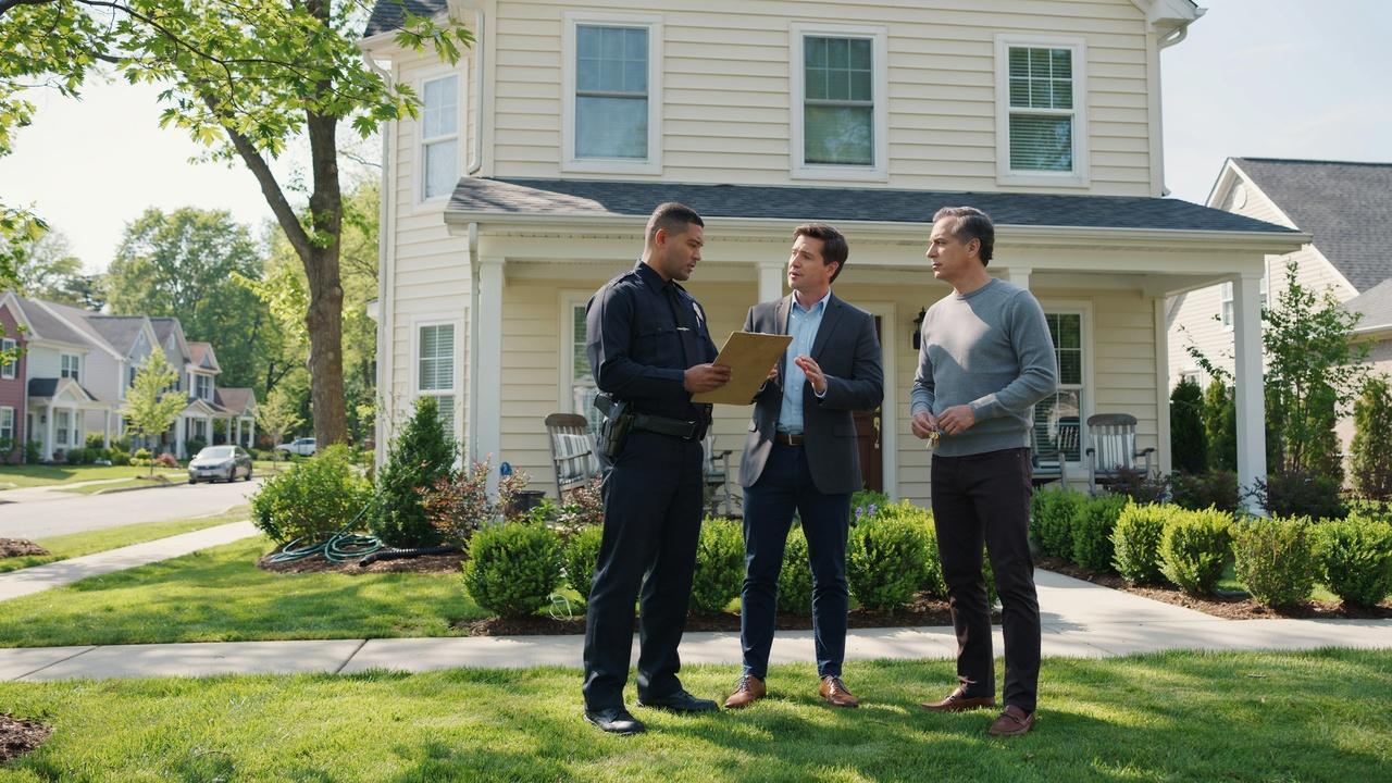 Property owner meeting with a law enforcement officer and attorney outside a residential property to discuss the legal removal process.