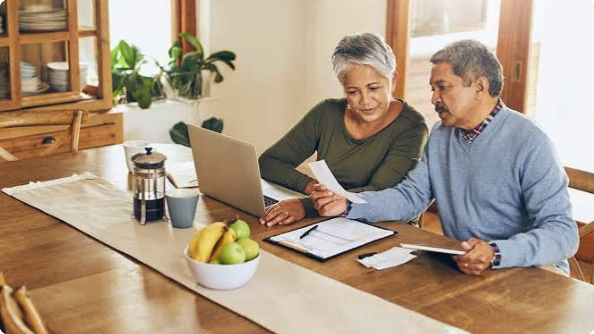 Older couple reviewing property papers on laptop for joint tenancy with rights of survivorship