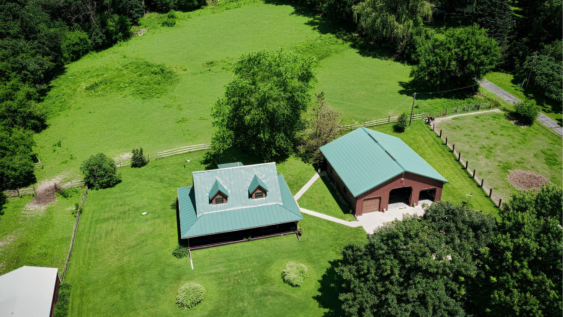 Aerial view of a rural property with house, barn, and surrounding acreage.