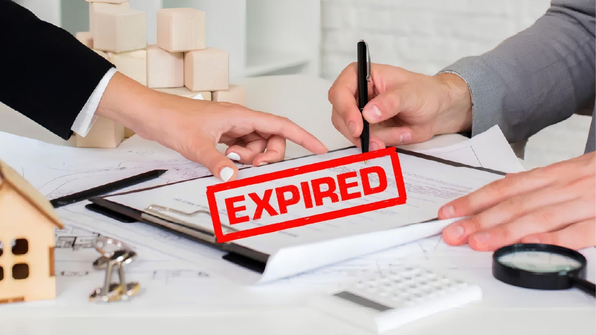 Two people reviewing property documents stamped EXPIRED with model house and plans