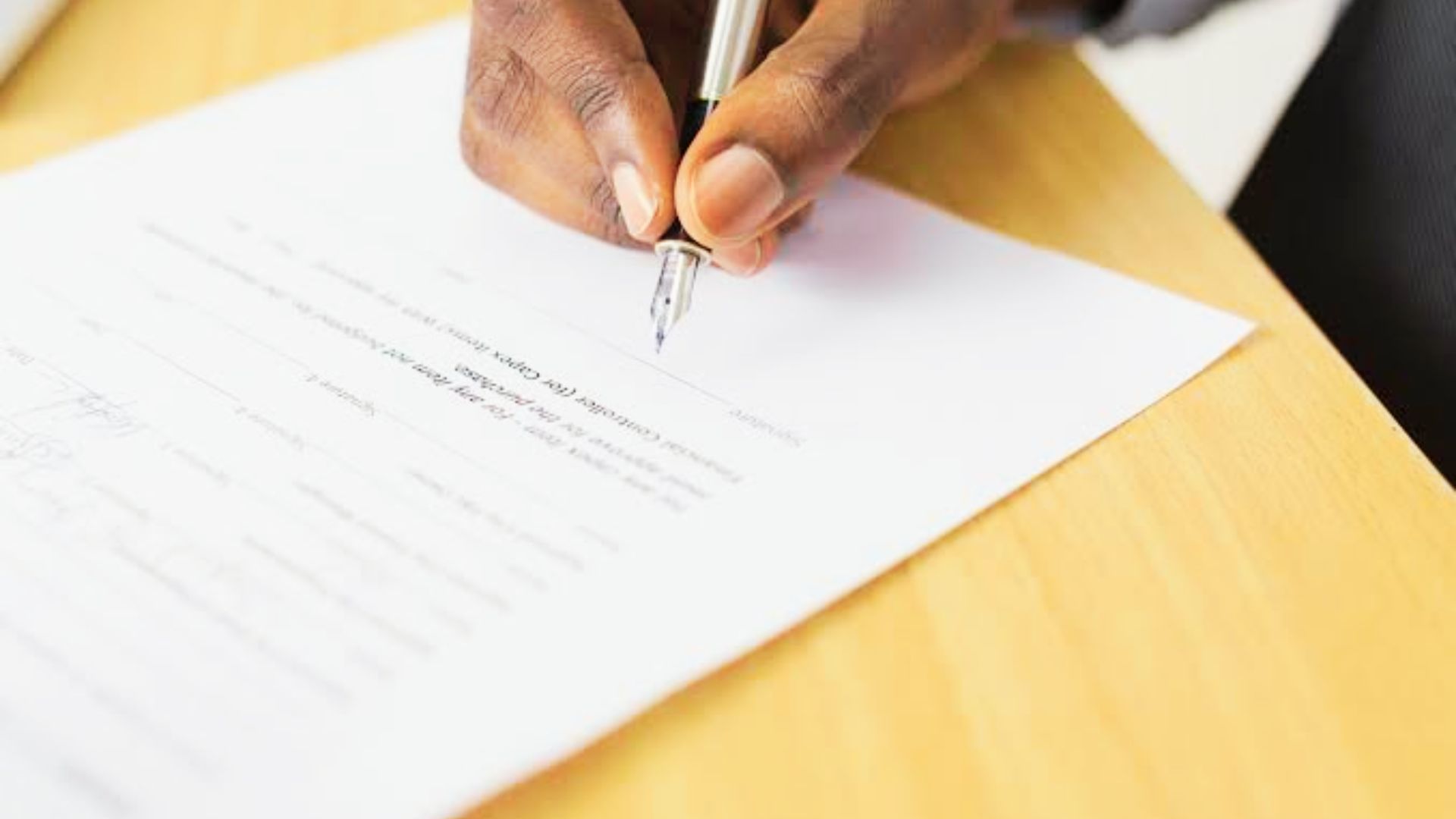 A man engaged in signing a sublet contract, illustrating the legal process of subletting a rental property.