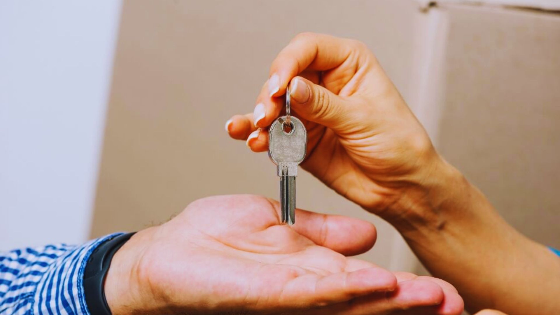 A person holding a house key, showing the experience of tenants sharing their stories and lessons learned.
