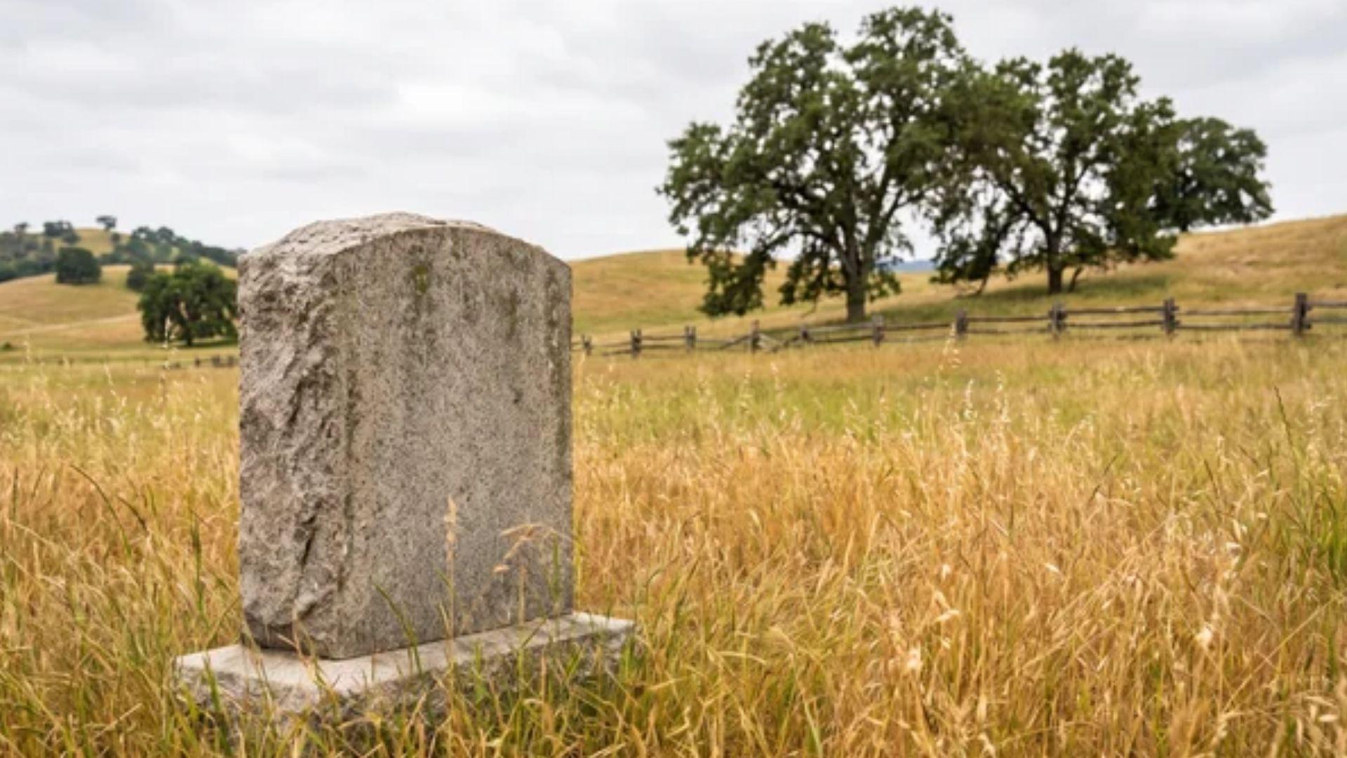Marked grave site on open rural land with a small stone marker.