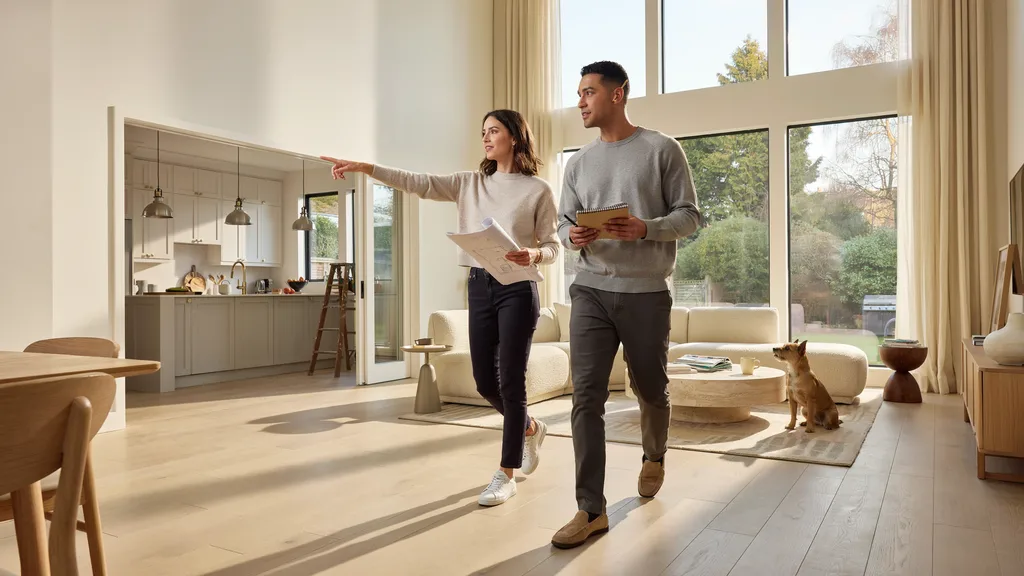 Two equal property owners inspecting and discussing decisions inside their shared home.