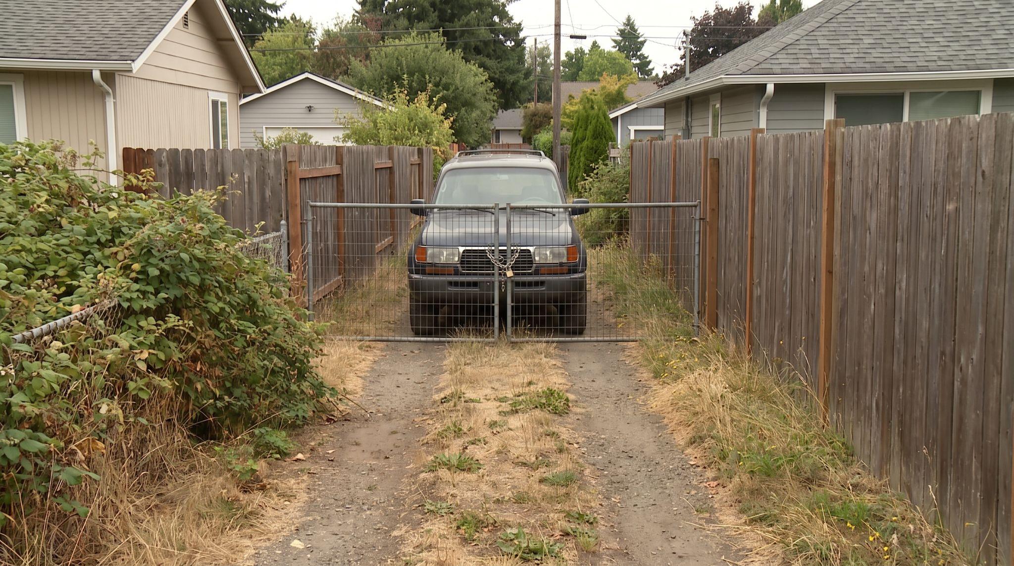 Easement access blocked by a fence, locked gate, and parked vehicle